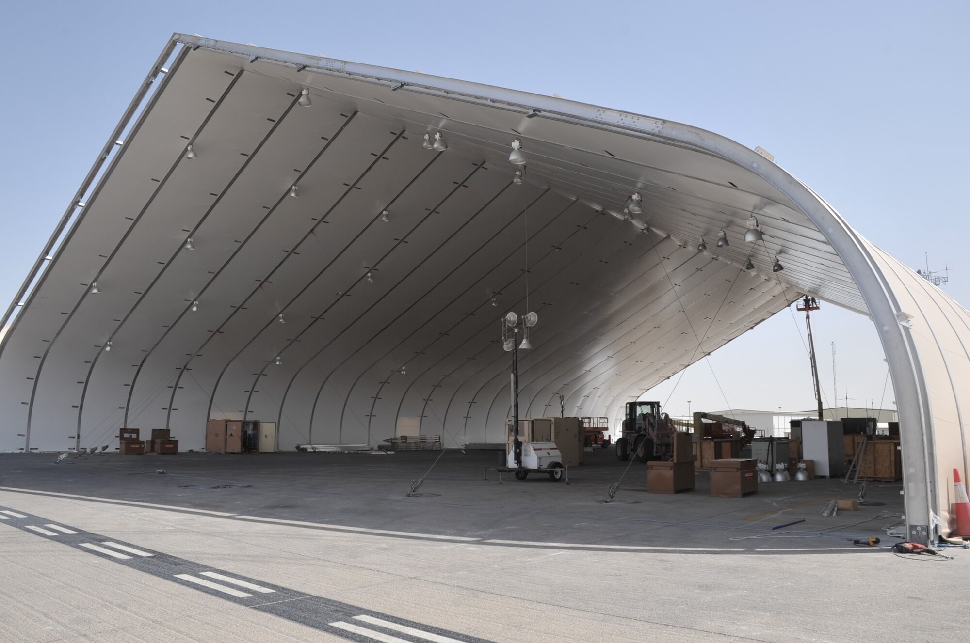 Airmen from the 380th Expeditionary Civil Engineer Squadron work on assembling covering for an expeditionary aircraft hangar during operations for the 380th Air Expeditionary Wing on June 2, 2010, at a non-disclosed base in Southwest Asia. Civil engineering Airmen having been working continuously for more than two months upgrading airfield structures for the 380th AEW. The 380th AEW supports operations Iraqi Freedom and Enduring Freedom and the Combined Joint Task Force-Horn of Africa. (U.S. Air Force Photo/Master Sgt. Scott T. Sturkol/Released)