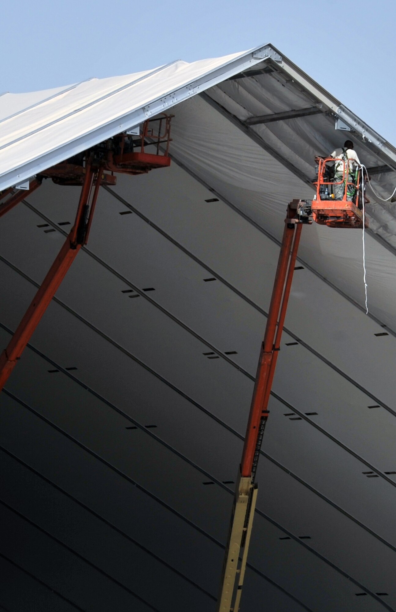 Airmen from the 380th Expeditionary Civil Engineer Squadron work on assembling covering for an expeditionary aircraft hangar during operations for the 380th Air Expeditionary Wing on June 2, 2010, at a non-disclosed base in Southwest Asia. Civil engineering Airmen having been working continuously for more than two months upgrading airfield structures for the 380th AEW. The 380th AEW supports operations Iraqi Freedom and Enduring Freedom and the Combined Joint Task Force-Horn of Africa. (U.S. Air Force Photo/Master Sgt. Scott T. Sturkol/Released)