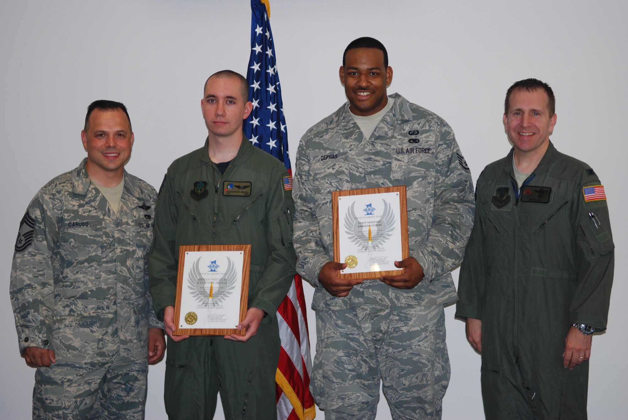 Chief Master Sgt. Matthew Caruso (left), 27th Special Operations Group chief , and Colonel James Slife (far right),  27th Special Operations Group commander, present Airman First Class Alexander Skidgel (left center), 16th Special Operations Squadron, and Staff Sgt. Rasheem Cephas (right center), 27th Comptrollers Squadron,with this month's Diamond Sharp Awards. Diamond Sharp Awards are presented monthly to Airmen in in recognition of their superior job performance, leadership skills, as well as dress and appearance. (U.S. Air Force Photo by Maj. Mae-Li Allison)

