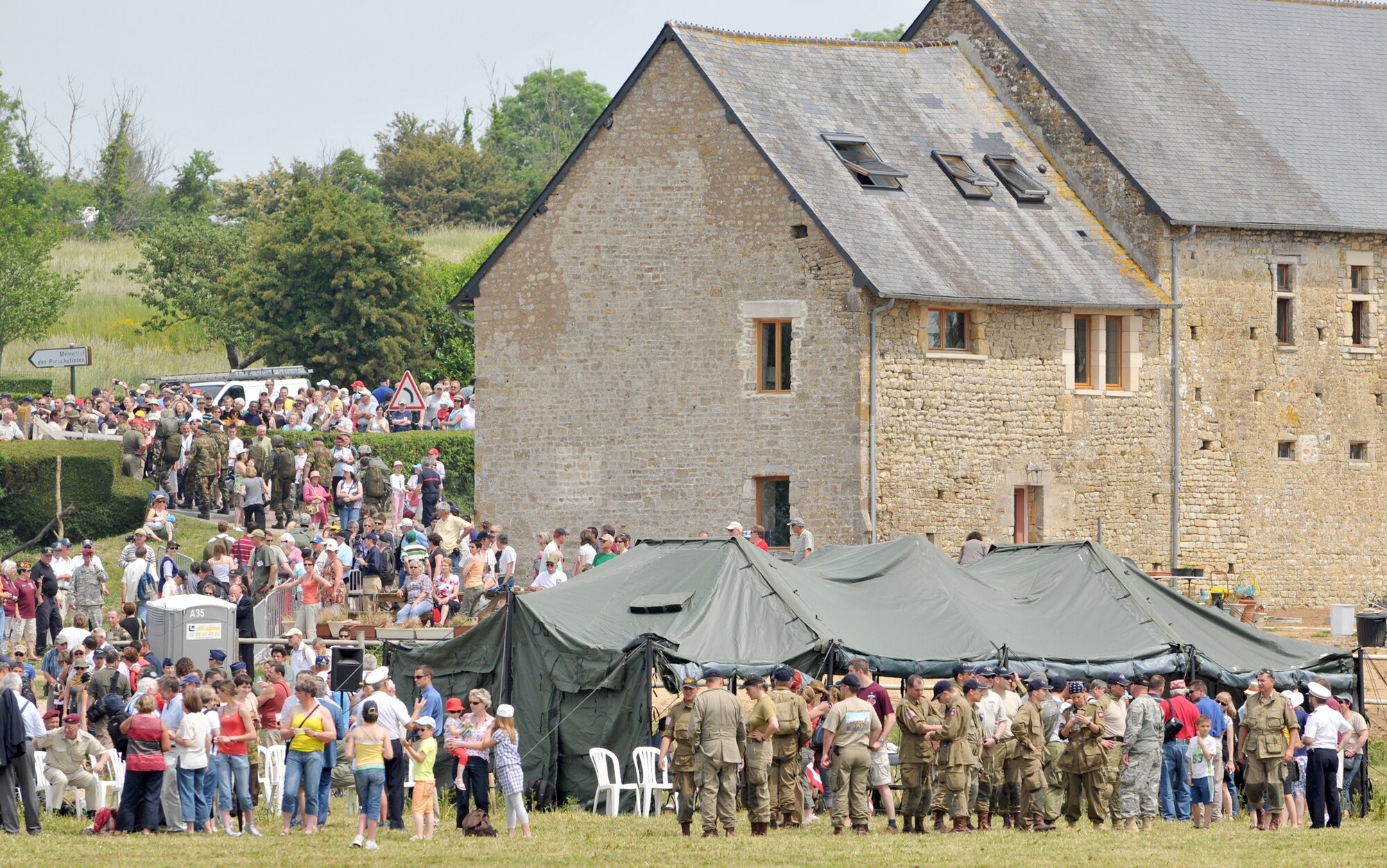 A crowd of spectators gathers to watch multinational paratroopers jump into the famous "Iron Mike" drop zone June 5, 2010, in Normandy, France. The jump was part of a ceremony commemorating the 66th anniversary of D-Day. (U.S. Air Force photo/Staff Sgt. Austin M. May)