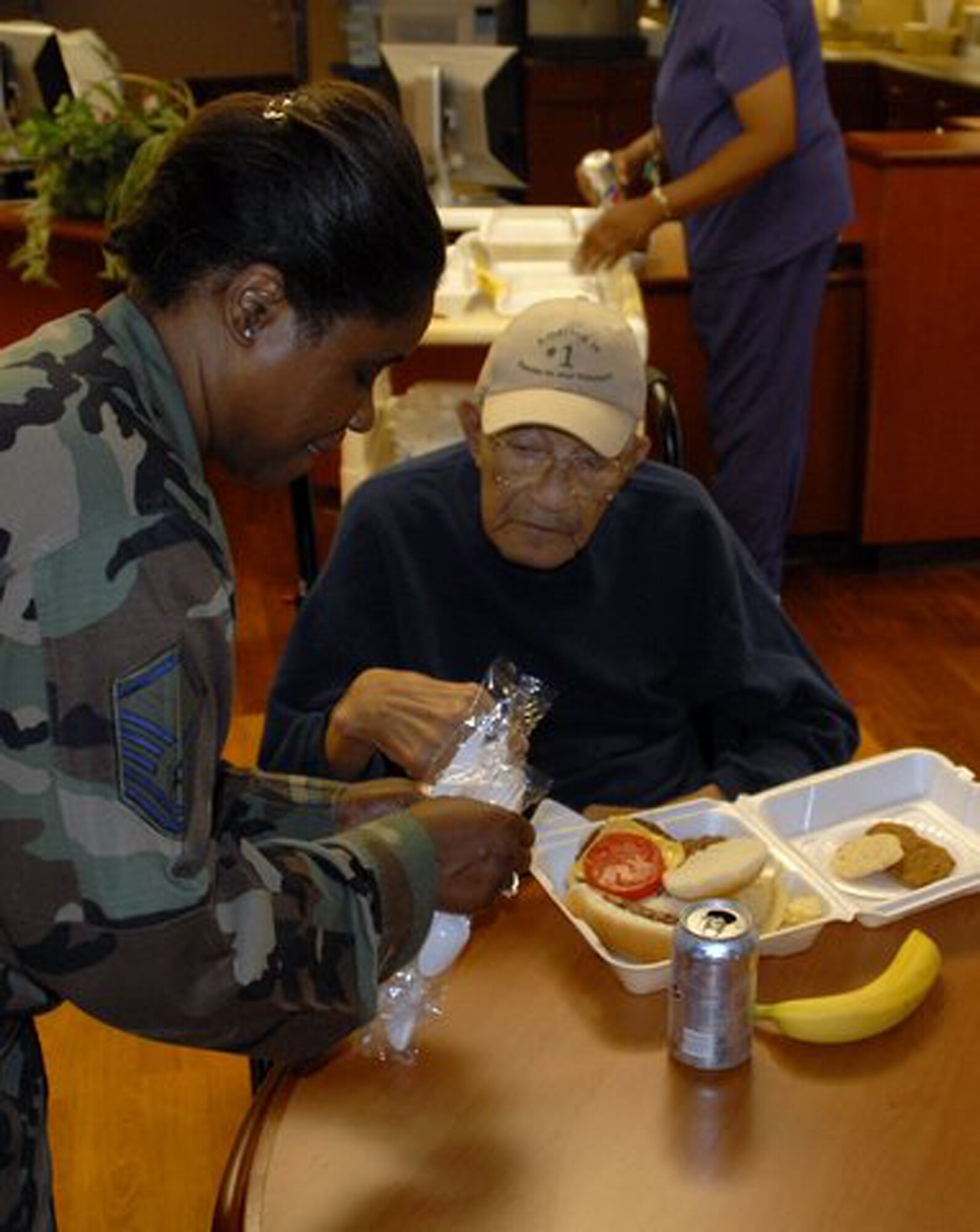WRIGHT-PATTERSON AIR FORCE BASE, Ohio – Master Sgt. Cynthia Holland, 445th Operations Group, helps a resident with his lunch during the annual VA picnic June 5 at the Veterans Affairs Medical Center in Dayton, Ohio.  Reservists from the 445th Airlift Wing support the event every year, working with the Air Force Sergeants Association Kittyhawk Chapter 751 and the Air Force Association to support the VA residents.  (U.S. Air Force photo/Master Sgt. Charlie Miller)