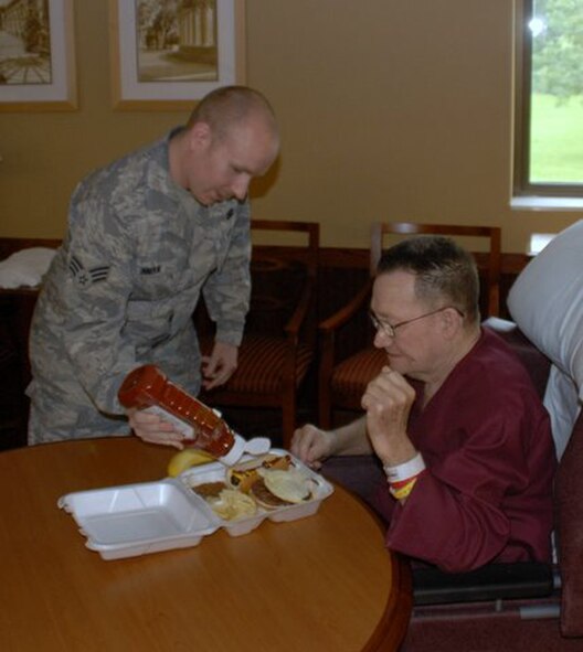 WRIGHT-PATTERSON AIR FORCE BASE, Ohio – Senior Airman Seth Inman, 445th Security Forces Squadron, helps a resident with his lunch during the annual VA picnic June 5 at the Veterans Affairs Medical Center in Dayton, Ohio.  Reservists from the 445th Airlift Wing support the event every year, working with the Air Force Sergeants Association Kittyhawk Chapter 751 and the Air Force Association to support the VA residents.  (U.S. Air Force photo/Master Sgt. Charlie Miller)
