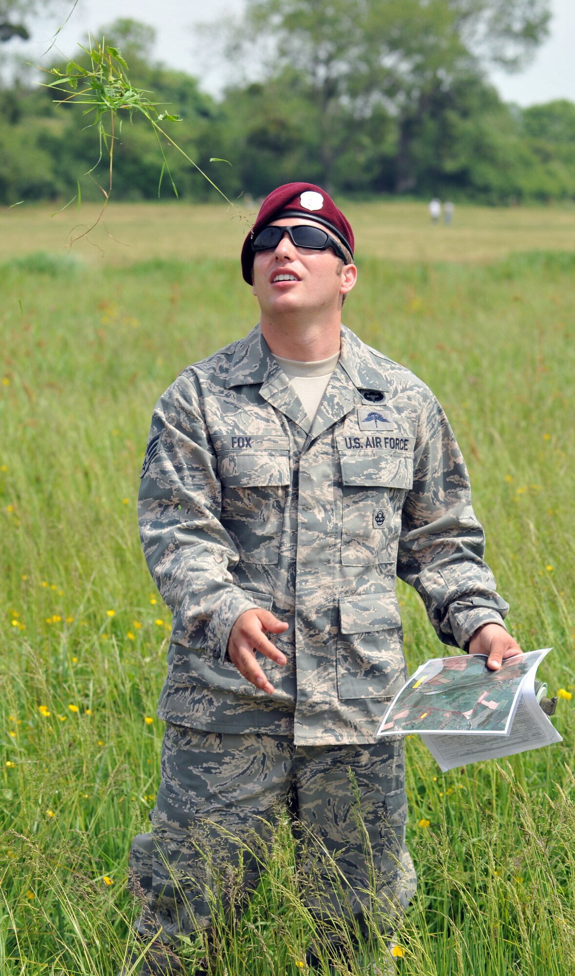 NORMANDY, France – A member of the 321st Special Tactics Squadron, RAF Mildenhall, England, checks wind direction by tossing grass into the air and seeing which way the wind carries it prior to a High Altitude, Low Opening parachute jump over the famous “Iron Mike” drop zone, where the Allies first landed on D-Day in 1944.  The Airmen participating in the jump were in France to commemorate the 66th anniversary of the start of the Allied invasion of Europe in World War II.  (U.S. Air Force photo/Staff Sgt. Austin M. May)