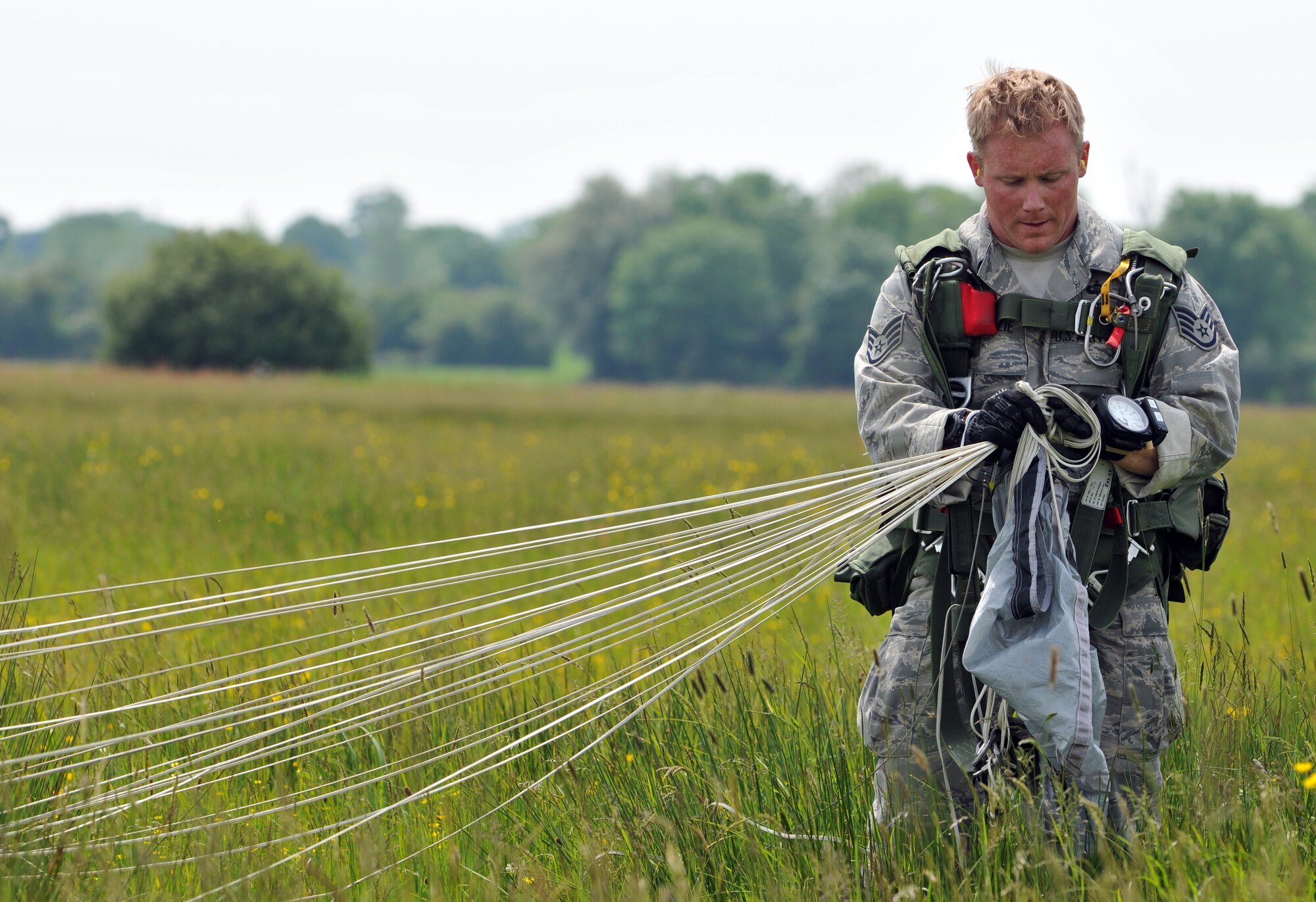 NORMANDY, France – A member of the 321st Special Tactics Squadron, RAF Mildenhall, England, gathers his gear after parachuting into the same drop zone used by Allies on D-Day.  The High Altitude, Low Opening jump was part of a ceremony commemorating the 66th anniversary of D-Day.  (U.S. Air Force photo/Staff Sgt. Austin M. May)