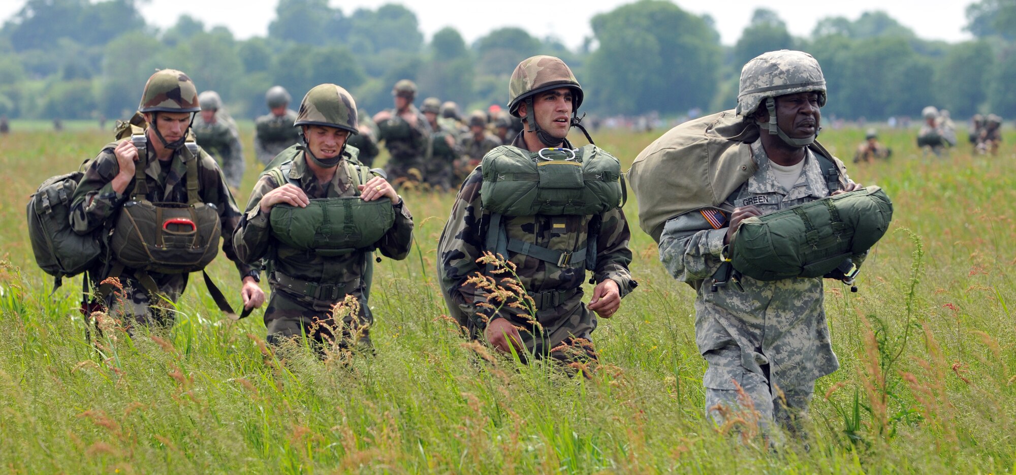 NORMANDY, France – French and American paratroopers hike to a muster area after parachuting into the same drop zone used by Allies on D-Day.  The June 5 jump was part of a ceremony commemorating the 66th anniversary of D-Day.  (U.S. Air Force photo/Staff Sgt. Austin M. May)