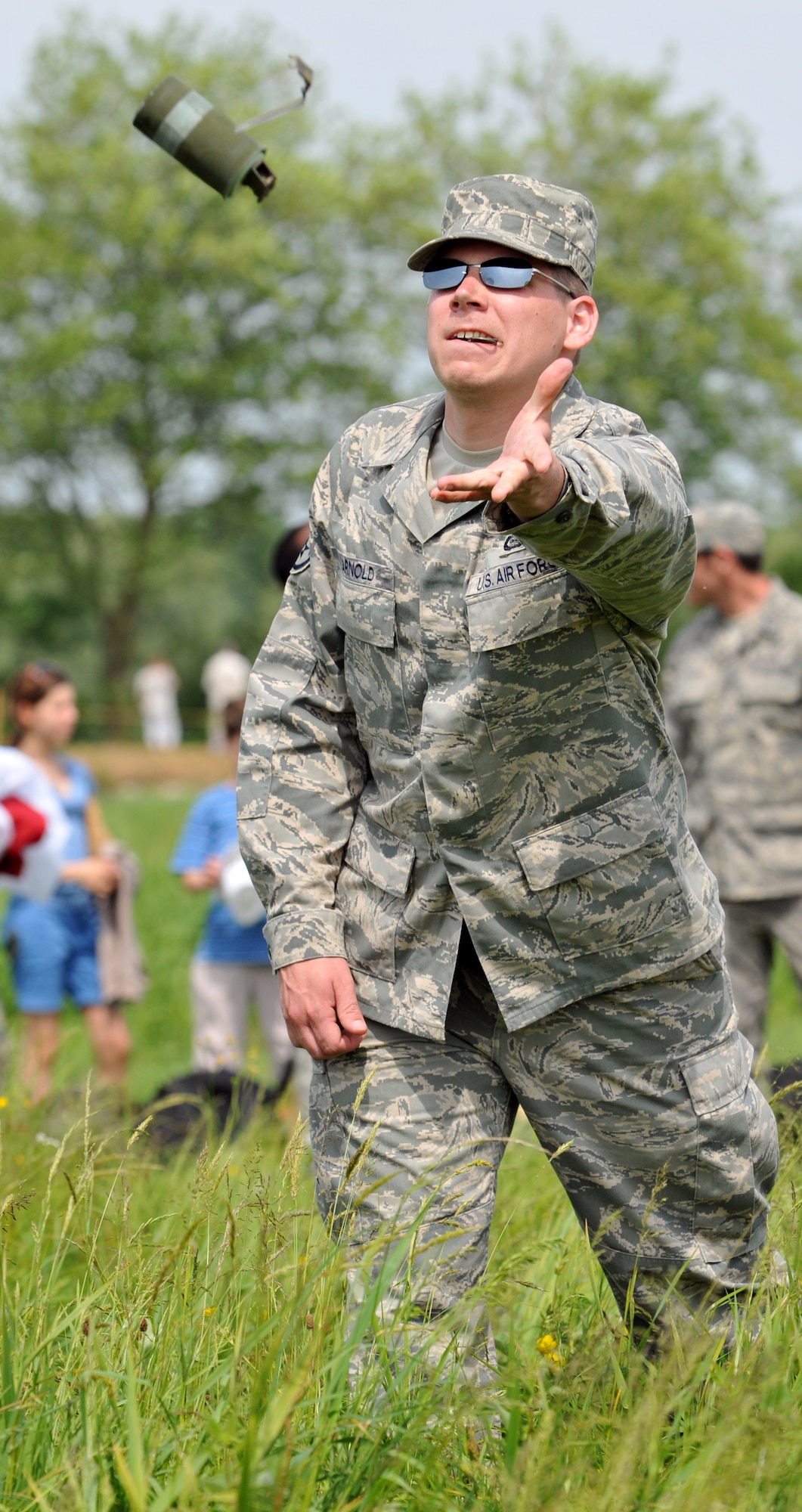 NORMANDY, France – A member of the 321st Special Tactics Squadron, RAF Mildenhall, England, throws a smoke grenade into the famous “Iron Mike” drop zone used by the Allies on D-Day.  The smoke helped mark the spot where High Altitude, Low Opening parachutists should land during a commemorative jump.  (U.S. Air Force photo/Staff Sgt. Austin M. May)
