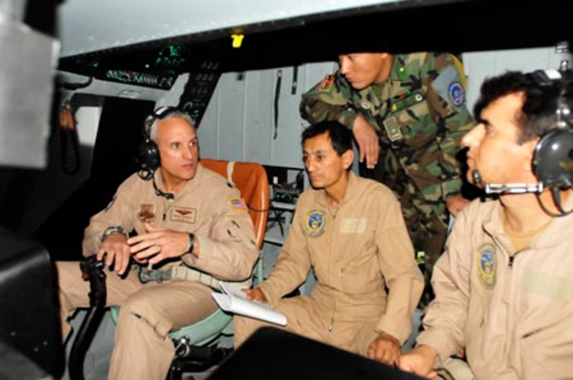 Lt. Col. Roger Figueroa flies a sortie in the Mi-17 helicopter simulator with his instructor pilots Qudratullah and Rametullah at the Afghan National Army Air Corps base in Kabul, Afghanistan. (U.S. Navy photo/MC1 Elizabeth Burke)