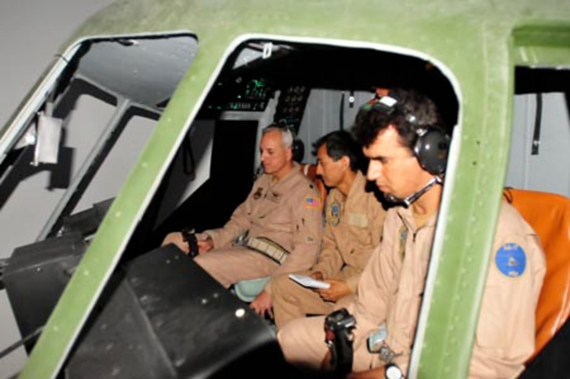 Lt. Col. Roger Figueroa flies a sortie in the Mi-17 helicopter simulator with his instructor pilots Qudratullah and Rametullah at the Afghan National Army Air Corps base in Kabul, Afghanistan. (U.S. Navy photo/MC1 Elizabeth Burke)