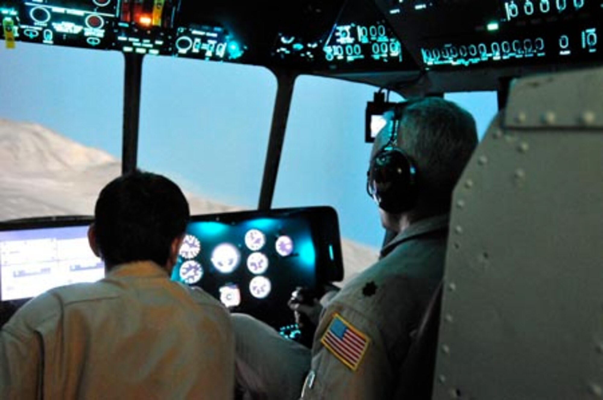 Lt. Col. Roger Figueroa flies a sortie in the Mi-17 helicopter simulator with his instructor pilots Qudratullah and Rametullah at the Afghan National Army Air Corps base in Kabul, Afghanistan. (U.S. Navy photo/MC1 Elizabeth Burke)