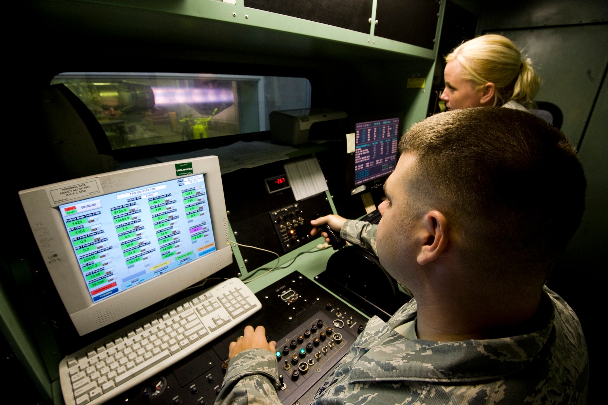 MISAWA AIR BASE, Japan -- Staff Sgts. Jared Langston and Tracy Madris, 35th Maintenance Squadron aerospace propulsion test cell technicians, throttle up a General Electric F110-GE-100 jet engine from an F-16 Fighting Falcon for a test run in the Hush House May 27. The sound-dampening control room protects operators from the 139-decibel roar of the engine. (U.S. Air Force photo/Staff Sgt. Samuel Morse)