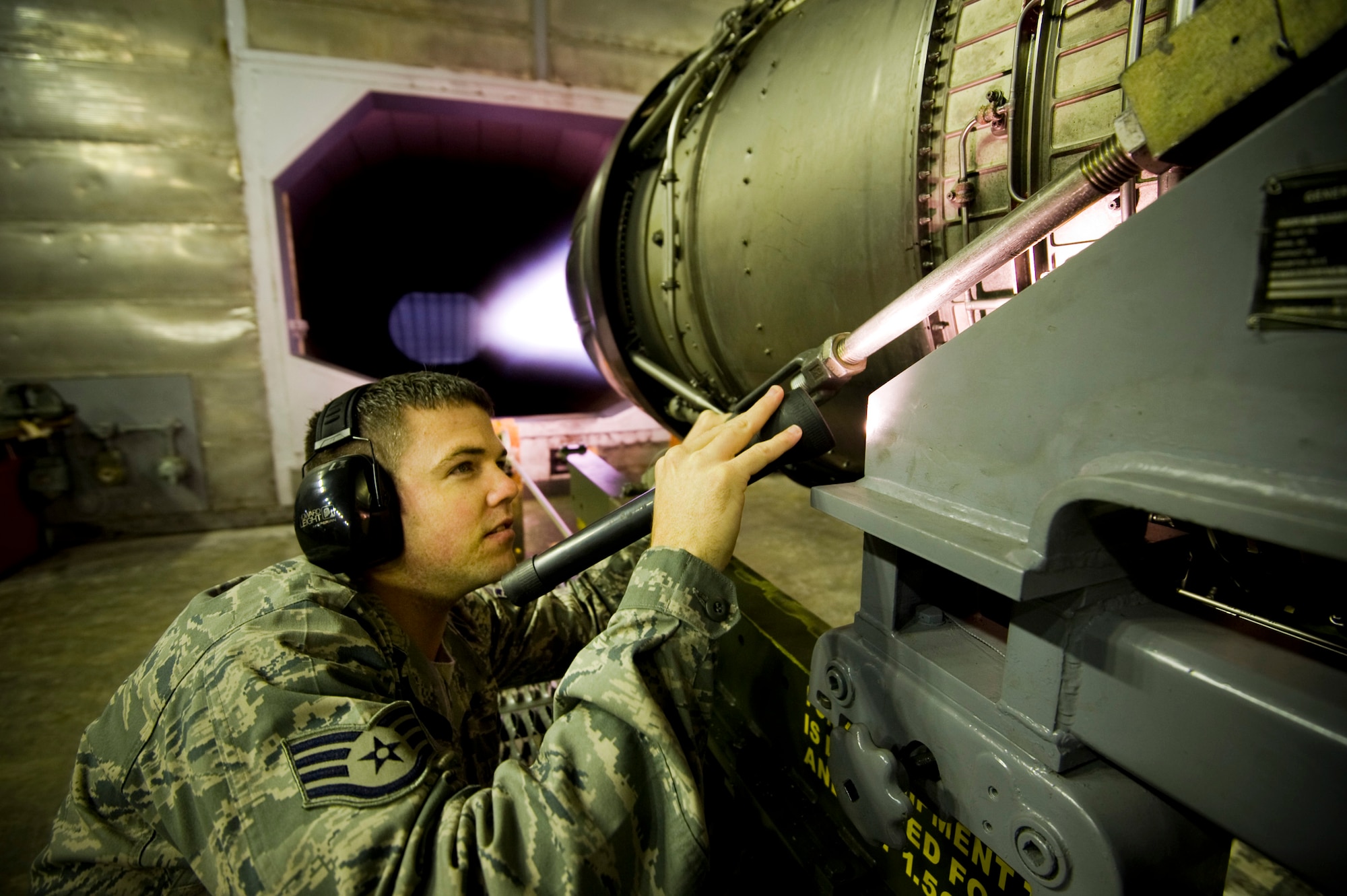 MISAWA AIR BASE, Japan -- Staff Sgt. Chris Browne, 35th Maintenance Squadron aerospace propulsion test cell technician, inspects the General Electric F110-GE-100 jet engine from an F-16 Fighting Falcon in the Hush House May 27. The Hush House allows maintainers to test and inspect the jet engines before returning them to the flightline. (U.S. Air Force photo/Staff Sgt. Samuel Morse)