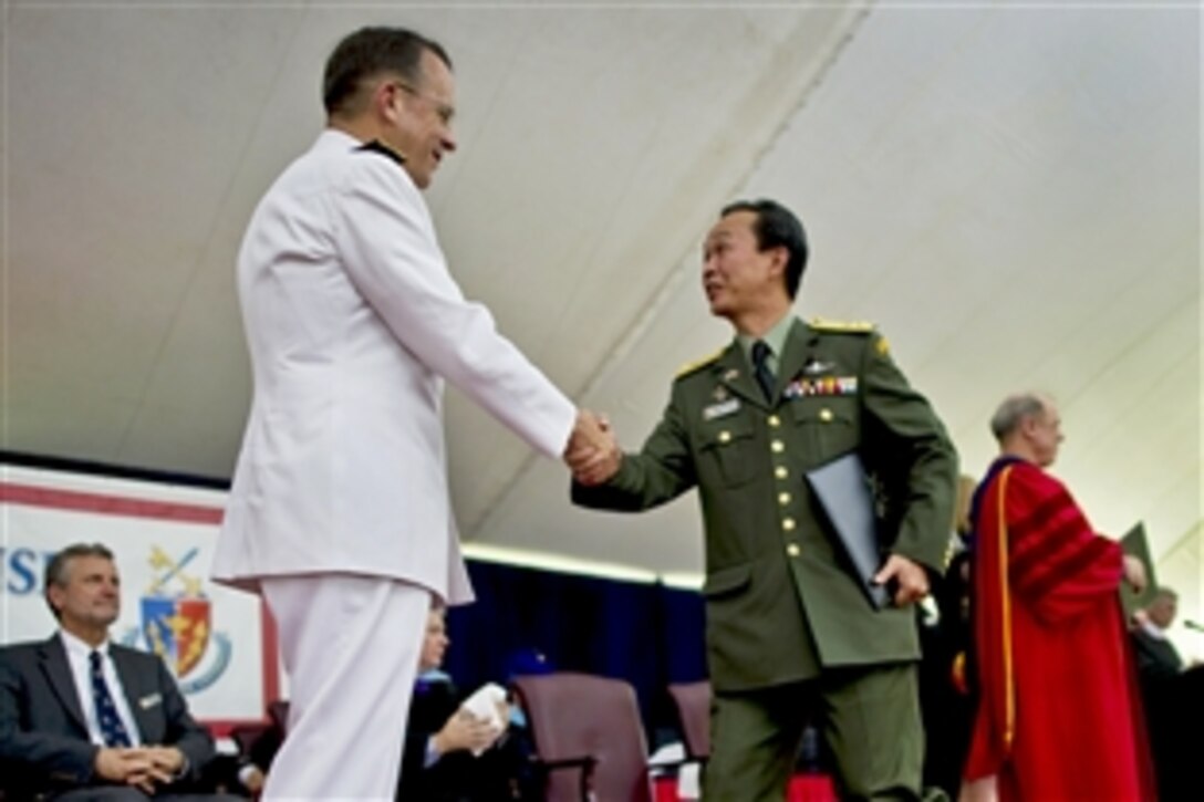 U.S. Navy Adm. Mike Mullen, chairman of the Joint Chiefs of Staff, congratulates a National Defense University graduate during commencement ceremonies on Fort Leslie J. McNair in Washington, D.C., June 10, 2010.