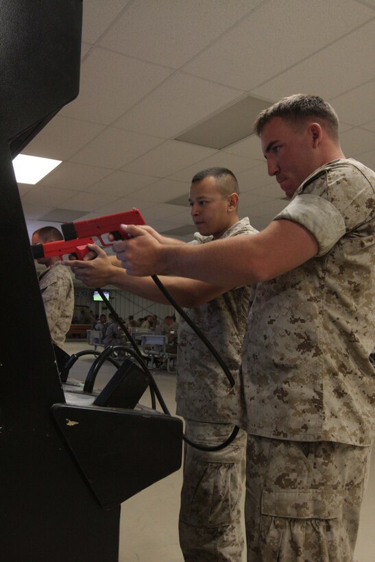 Lance Corporals. Gregorio Vasquez and Mathew Carroll, both motor transportation drivers with the Mojave Viper Support Detachment, play the arcade-style video game Time Crisis at the Warriors Club June 11. The Club has many games Marines and sailors can choose from, ranging from racing to shooters.