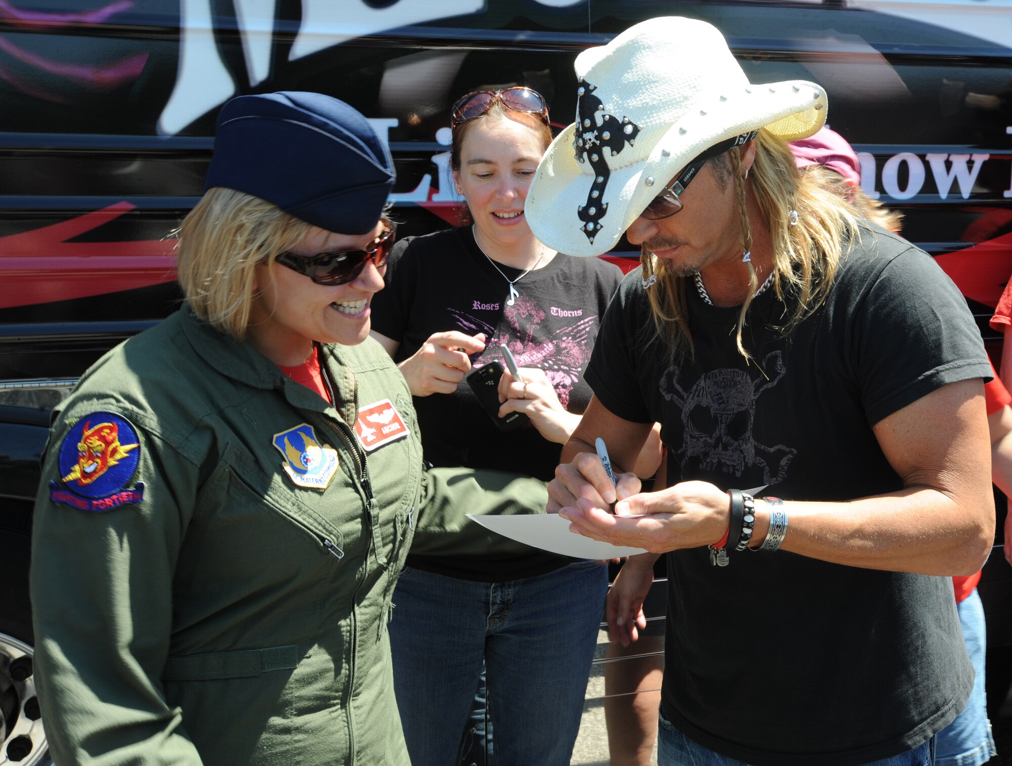 Bret Michaels autographs a picture for Senior Master Sgt. Joy Josephson, 40th Flight Test Squadron, Eglin Air Force Base, Fla., at the Hurlburt Field Base Exchange during his visit to Hurlburt Field, Fla., June 11, 2010.  The picture being signed is a photo of Bret Michaels and Sergeant Josephson which was taken when she was deployed to the Southwest Asia in 2009. (DoD photo by U.S. Air Force Senior Airman Matthew Loken/Released)