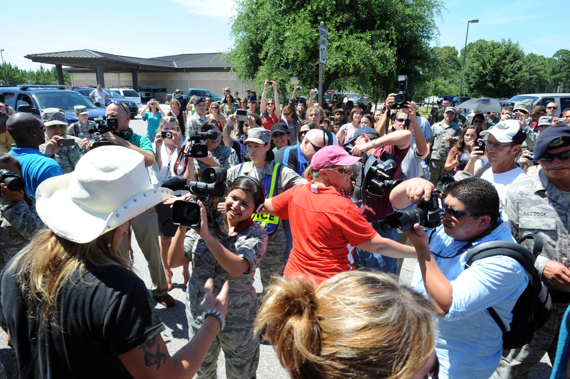 Airman 1st Class Danielle Colberg, a broadcaster from the 1st Special Operations Wing Public Affairs office, interviews Bret Michaels at the base exchange parking lot during his visit to Hurlburt Field, Fla., June 11, 2010.  (DoD photo by U.S. Air Force Senior Airman Matthew Loken/Released)