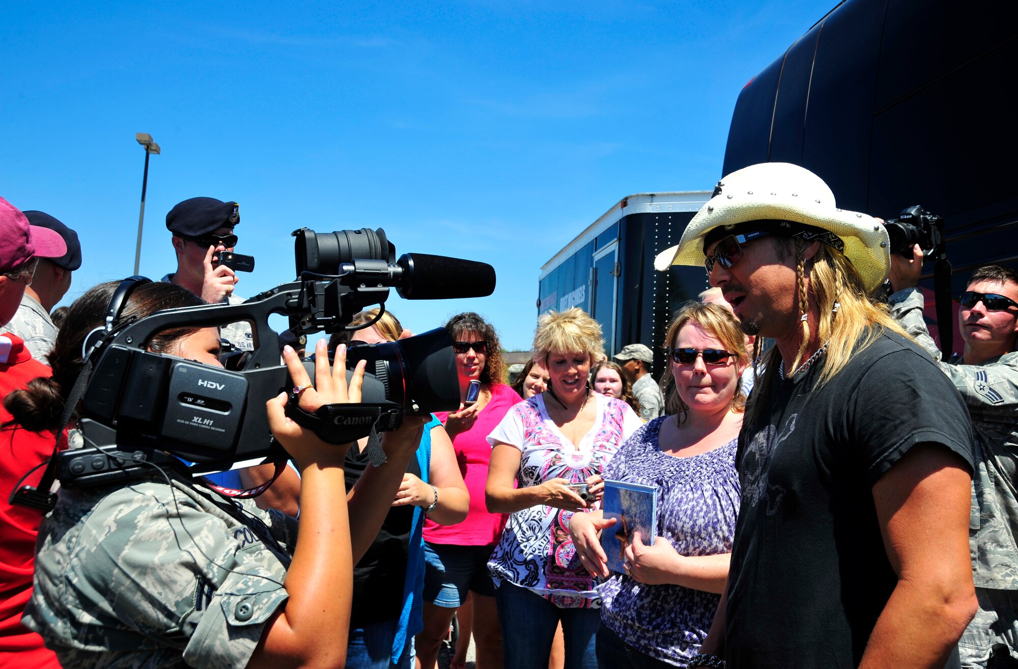 Airman 1st Class Danielle Colberg, a broadcaster assigned to the 1st Special Operations Wing Public Affairs office, interviews Bret Michaels at the Hurlburt Field Base Exchange parking lot during his visit to Hurlburt Field, Fla., June 11, 2010.  (DoD photo by U. S. Air Force Senior Airman Sheila L. deVera/Released)