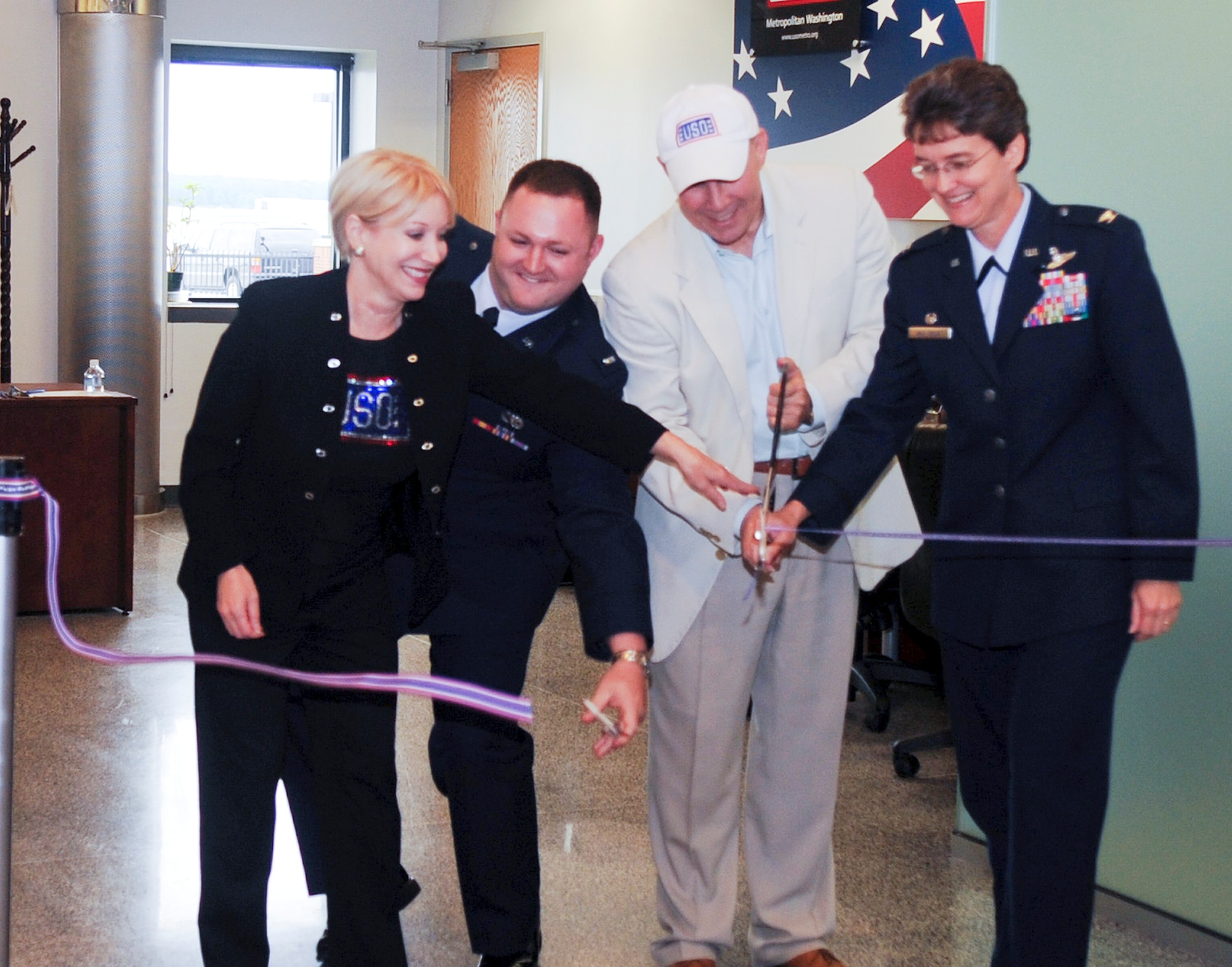 JOINT BASE ANDREWS, Md. -- Elaine B. Rogers, USO of metropolitan Washington president, left, 1st Lt. Jason Castleberry, 89th Aerial Port Squadron passenger operations officer, John Marselle, chairman of the board for the USO, and Col. Jacqueline Van Ovost, 89th Airlift Wing commander, cut the ribbon for opening ceremonies at the passenger terminal June 9. The USO has been located inside the passenger terminal since 1995. Its volunteers have assisted 1154 military and families members so far in 2010. (U.S. Air Force photo by Senior Airman Melissa Brownstein)