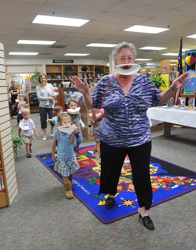 JOINT BASE ANDREWS, Md. -- Cheryl Gritton, Base Library director, aka "Mama Duck," leads a group of her ducklings (Andrews youth) through the library during a celebration of Donald Duck’s 50th birthday June 9. Ms. Gritton read the children several books relating to ducks and later the children colored paper plate-fashioned duck bills after the bi-weekly Story Time session. Story Time is held at the Base Library Mondays at 5:30 p.m. and Wednesday, at 10 a.m. (U.S. Air Force photo by Bobby Jones)