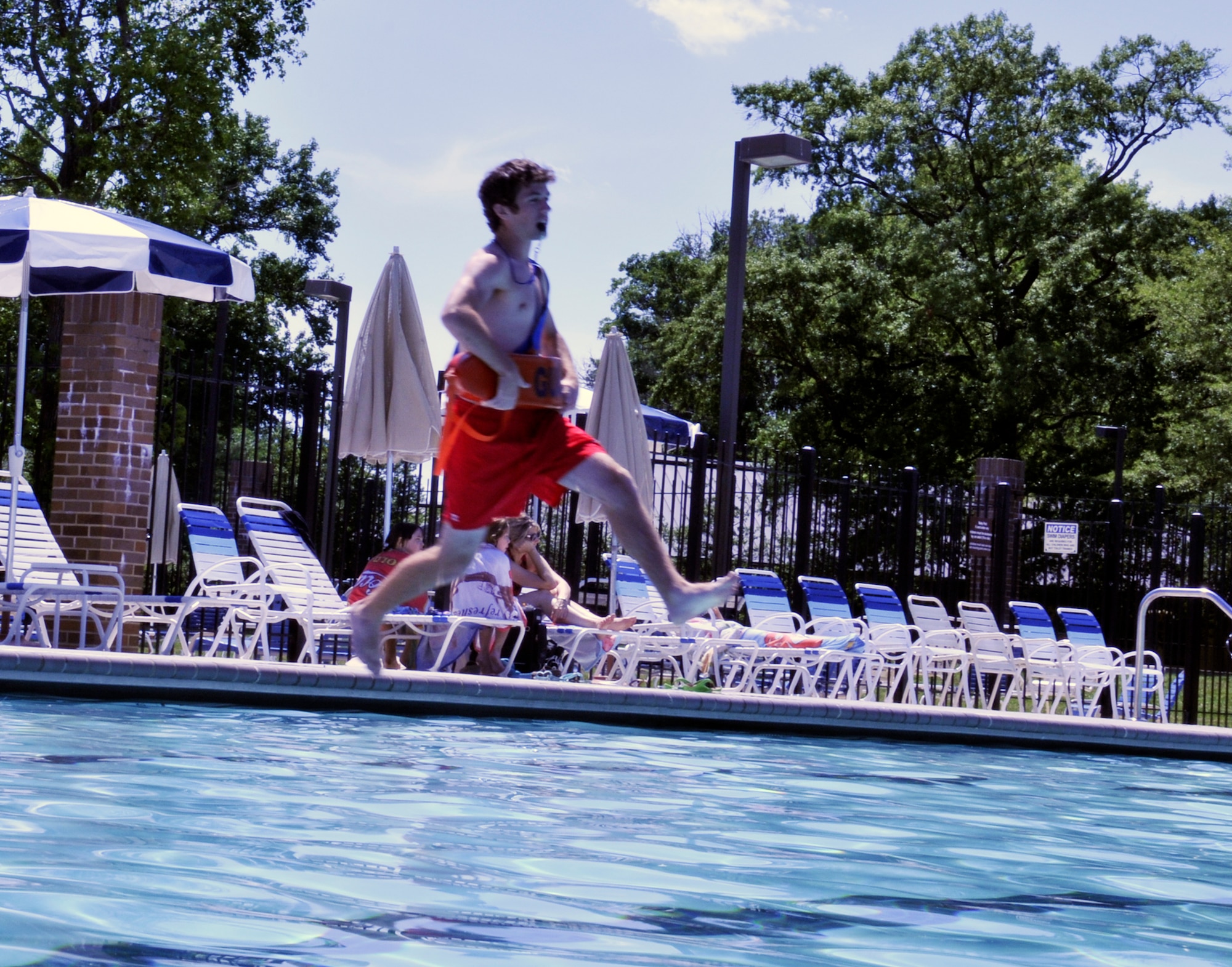 JOINT BASE ANDREWS, Md. -- Justin Miller, lifeguard at the Gateway Pool on Joint Base Andrews, demonstrates how to perform a stride rescue jump into the water to save a victim, June 8, 2010. The stride jump is used to enter the water while keeping an eye on the victim at all times. Mr. Miller has worked at the Gateway Pool for three summers and is a resident of Joint Base Andrews.  (U.S. Air Force photo by Senior Airman Katie Spencer)