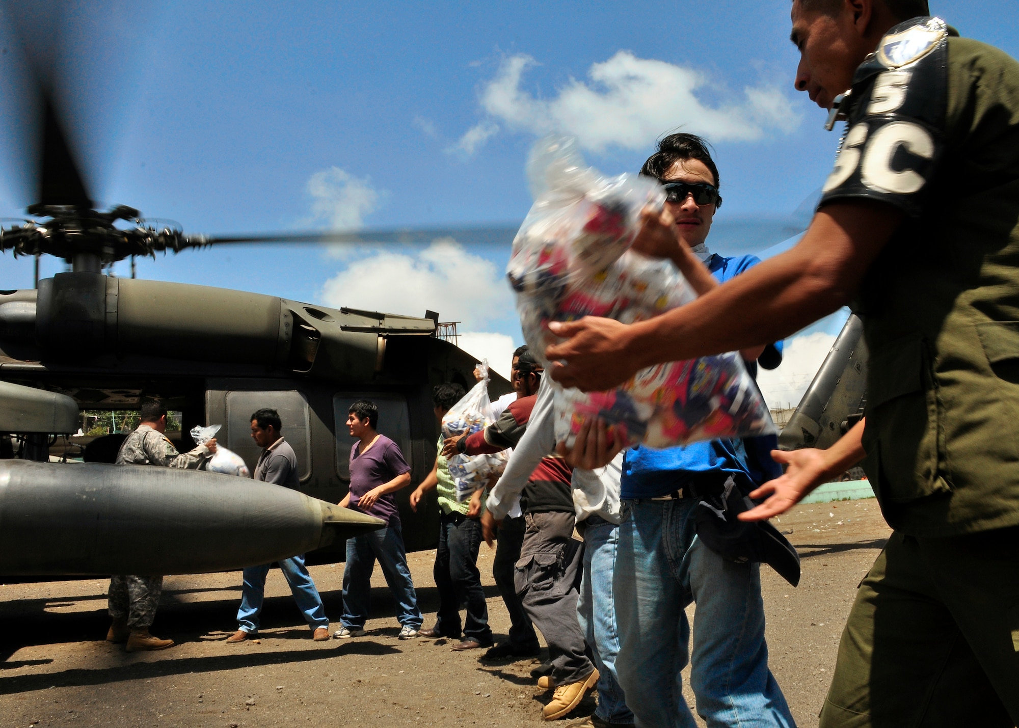 Guatemalans begin offloading food and water from a Joint Task Force-Bravo UH-60 Blackhawk June 6, 2010, in the community of Santiago Atitlan, Guatemala. Joint Task Force-Bravo's helicopters have transported approximately 53,000 pounds of relief supplies to 14 Guatemalan communities since June 2 to support the Guatemalan government's disaster relief efforts following the Pacaya volcano eruption and Tropical Storm Agatha. (U.S. Air Force photo/Staff Sgt. Bryan Franks)
