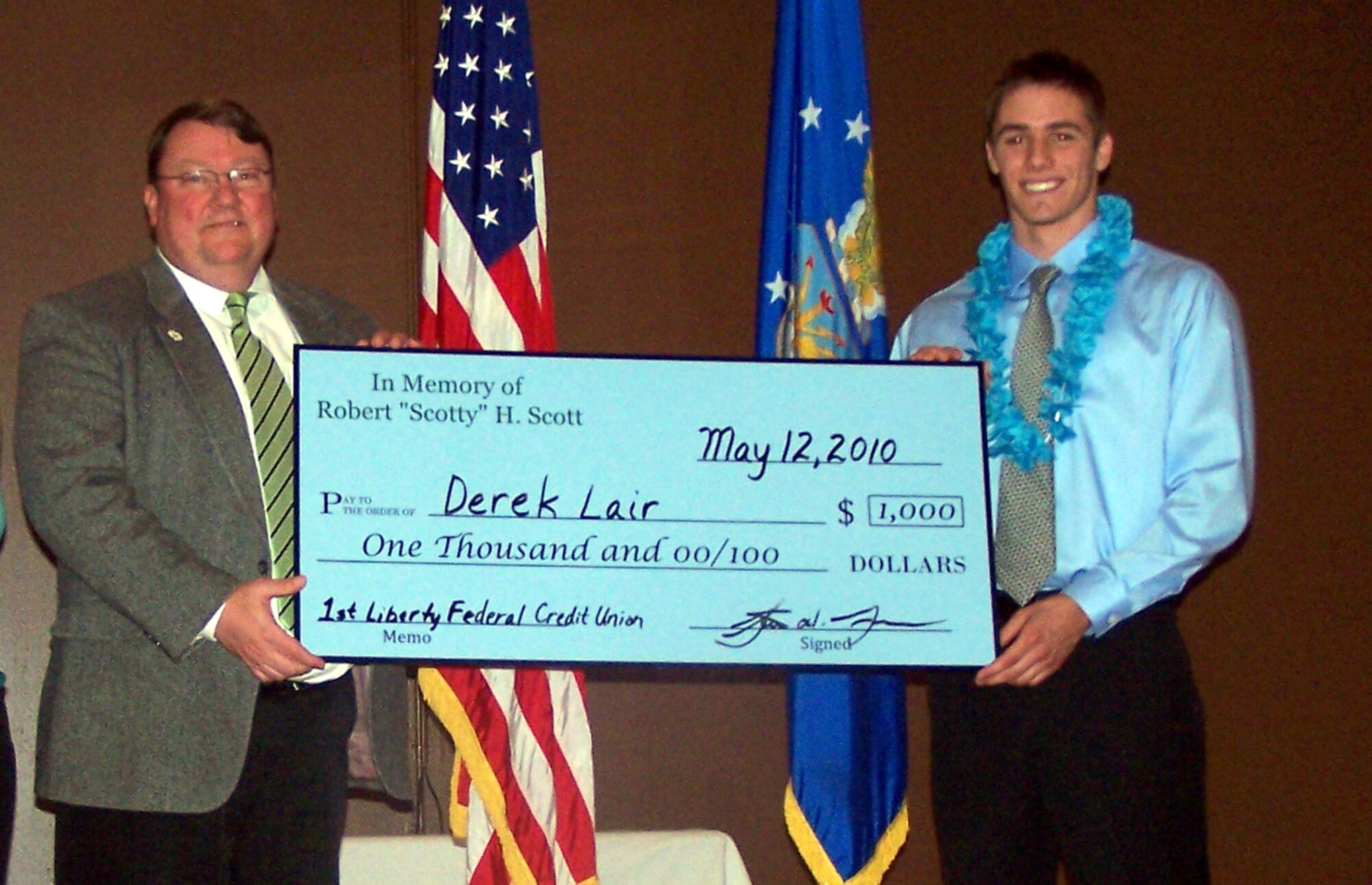 Mr. Steve Grooms, President and CEO of 1st Liberty Federal Credit Union, presents a $1,000 "check" to Derek Lair during a scholarship reception at the Grizzly Bend Club. (Courtesy photo)