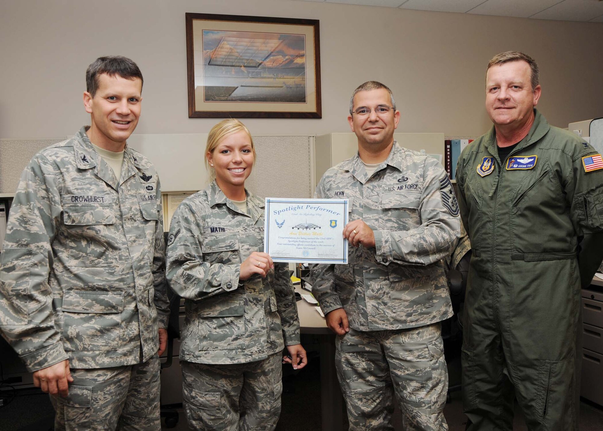 Airman Brittnie Mathi, 931st Maintenance Operations Flight Knowledge Operations manager (center), proudly displays the Spotlight Performer certificate presented to her by (from left to right) Col. James Crowhurst, 22nd Air Refueling Wing commander, Chief Master Sgt. Timothy Horn, 22nd ARW command chief and Col. Edsel Frye, Jr., 931st Air Refueling Group commander at her on June 10. The Kansas City, Mo. native is responsible for mainting military orders files, handling, directing, governing and controlling natural knowledge process with the unit. (U.S. Air Force photo/Airman First Class Andrea Salazar)