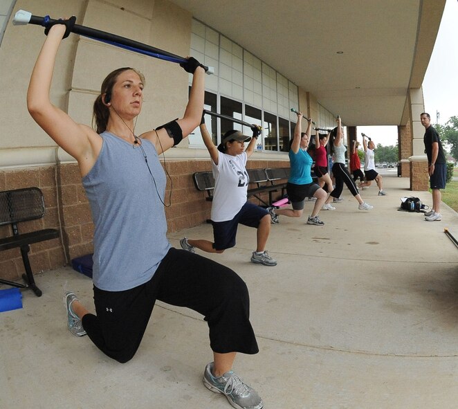 BARKSDALE AIR FORCE BASE, La. ? (Far left) Staff Sgt. Bianca Jans, 2d Logistics Readiness Squadron, and other Barksdale members, perform a standing lunge during the Health and Wellness Center?s basic training class June 9. The class is designed to improve an individual's overall health and physical fitness and is held 5:15 p.m. Monday through Thursday in front of the base fitness center. (U.S. Air Force photo/Senior Airman Amber Ashcraft) (RELEASED)