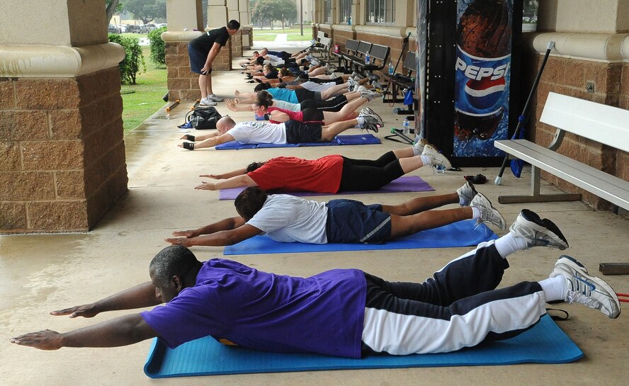 BARKSDALE AIR FORCE BASE, La. ? Barksdale members perform the ?superman? during the Health and Wellness Center?s basic training class June 9. The class is designed to improve an individual's overall health and physical fitness and is held 5:15 p.m. Monday through Thursday in front of the base fitness center. (U.S. Air Force photo/Senior Airman Amber Ashcraft) (RELEASED)