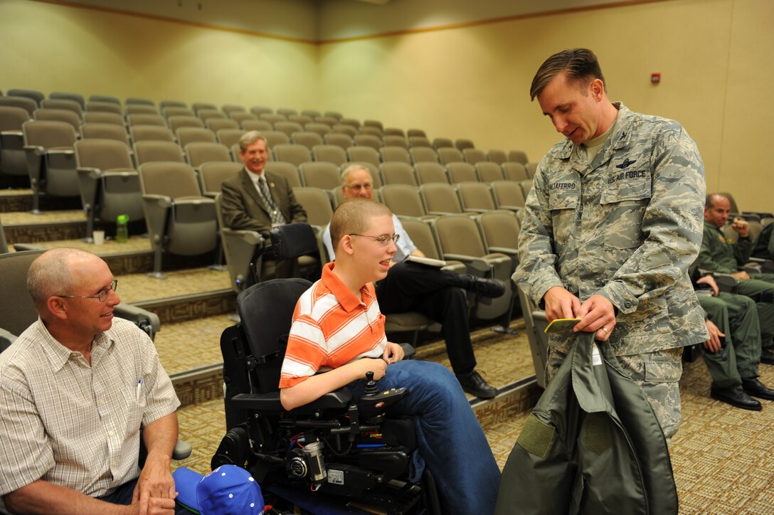 ELLSWORTH AIR FORCE BASE, S.D.-- Wade Ginkens receives his aircrew jacket from Col. Jeffrey Taliaferro, 28th Bomb Wing Commander, during his visit here, June 10. Wade participated in the "Aircrew for a Day" program which focuses on children stricken with illnesses who are unable to enjoy many  activities.(U.S. Air Force photo/Master Sgt. Loren J. Bonser)

