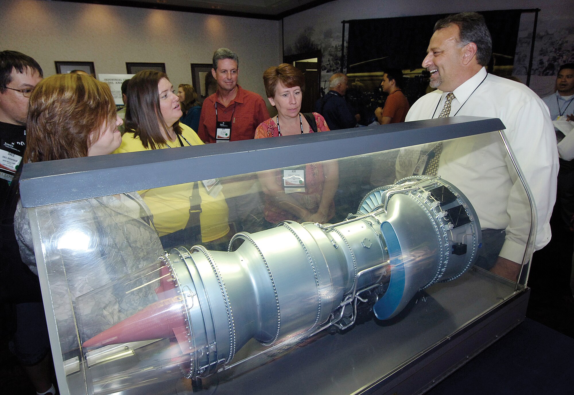 Staged by a TF33 engine model, Tinker’s Lindsey Higdon answers questions about careers here during a reception held for state educators during last week’s Oklahoma Aerospace Summit activities.  The event held in the air logistics center was to inform the educators about careers for students.(Air Force photo by Margo Wright)