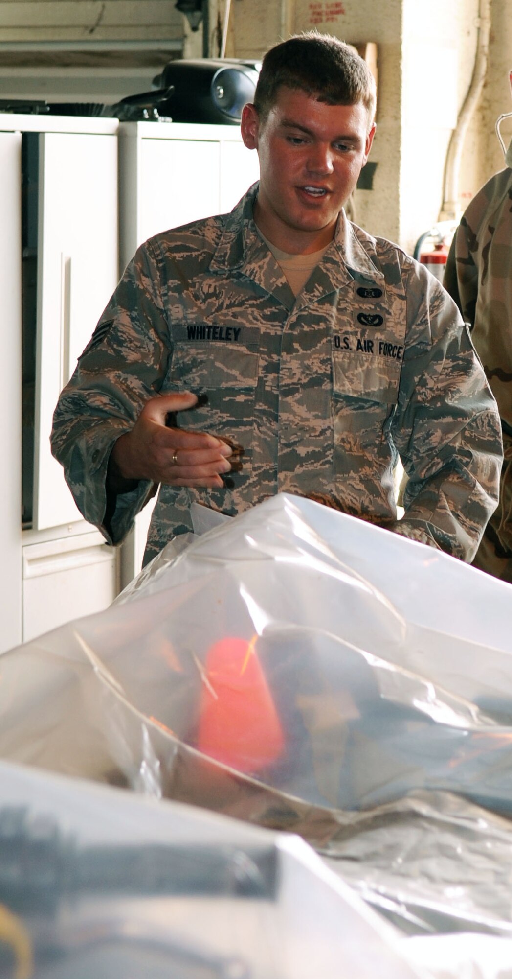 BARKSDALE AIR FORCE BASE, La. ? Senior Airman James Whiteley, 2d Civil Engineering Squadron emergency management journeyman, explains how to properly cover a vehicle that has been exposed in a chemical attack during the emergency management training held June 6. This training covers a wide variety of threats that may potentially occur on Air Force installations. (U.S. Air Force photo by Senior Airman La?Shanette V. Garrett)(RELEASED)
