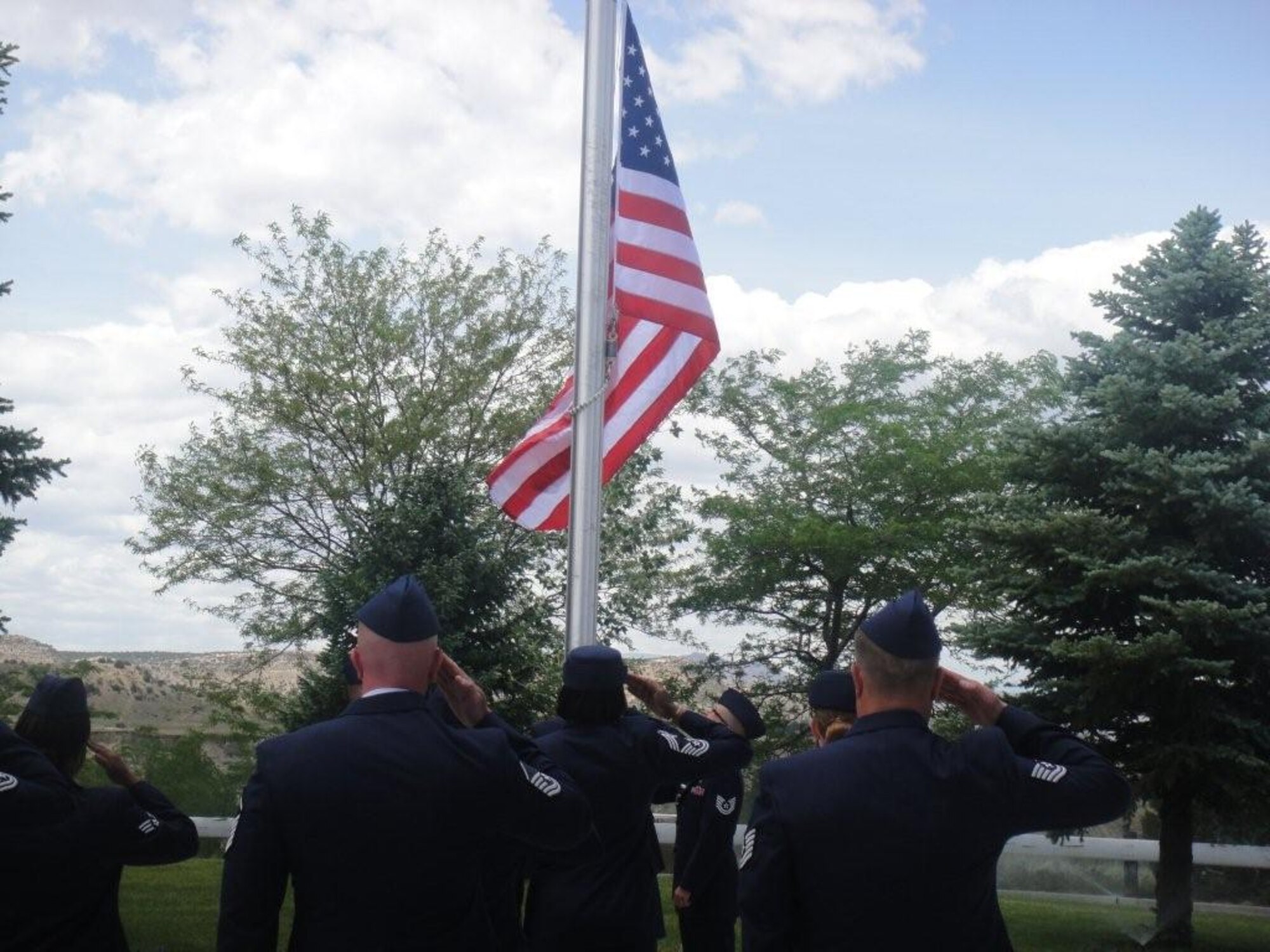 Members of the Vosler NCO Academy staff salute as a new U.S. flag they supplied goes up June 2 at the Bruce McCandless VA nursing home in Florence, Colo. Staff members from the Vosler NCOA donated a flag to the home, replacing and retiring a weathered flag that was flying there. (Courtesy photo)