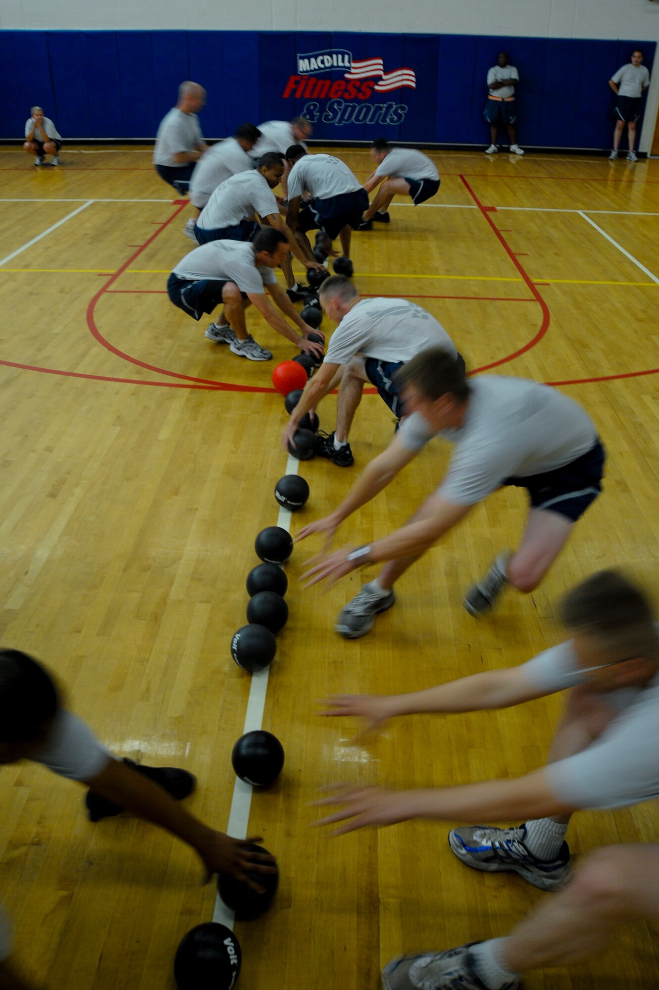 Airmen from the 6th Air Mobility Wing race toward the center of the court to start a game of dodgeball during the 6th AMW Sports Day at MacDill Air Force Base, Fla., Jun. 11, 2010.  Members from the 6 AMW participated in a number of different sporting events during Sports Day to promote fun and camaraderie.  (U.S. Air Force photo by Staff Sgt. Joseph L. Swafford Jr./Released)