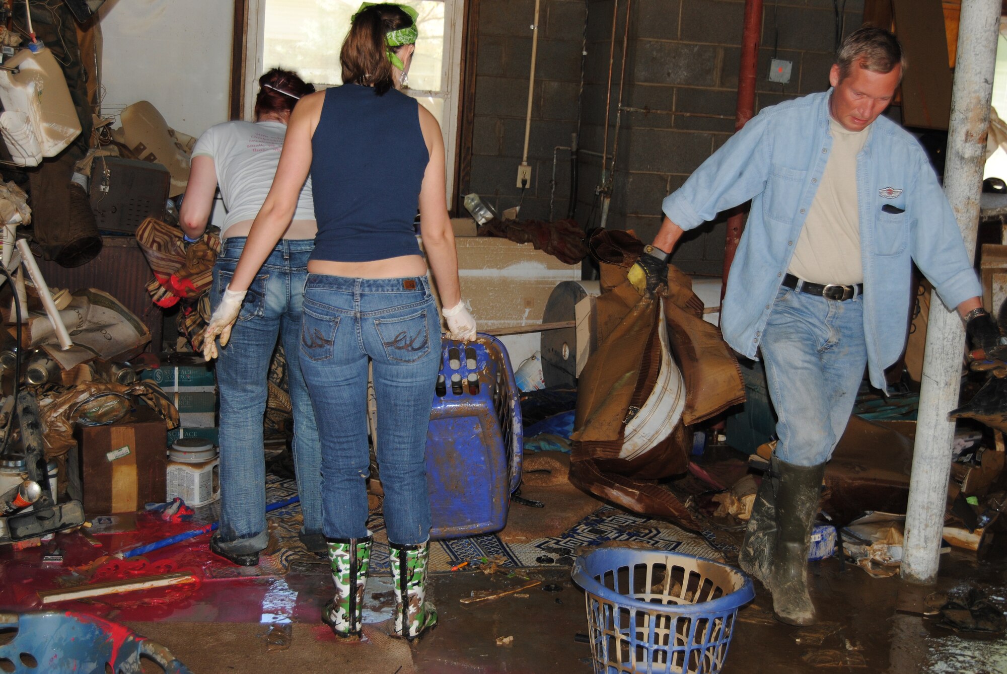 May 8, Jessica Armocida and Stephanie Moyer assist SMSgt Jim Johnson, 118th Airlift Wing Aircrew Flight Equipment Superintendent, is cleaning out his garage after it was destroyed by the May 1 and 2 flooding.