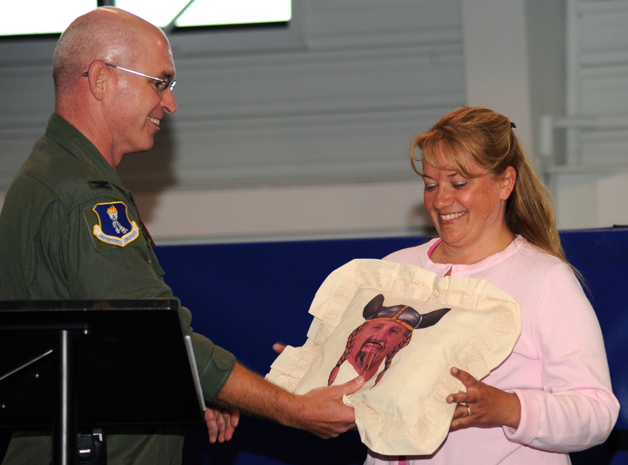 Col. John Quinn, 319th Air Refueling Wing vice-commander (left), gives a farewell gift to Chief Master Sergeant Scott Fuller, 319 ARW command chief’s wife, Tracy Fuller during his going away barbeque, June 10, at Liberty Square here. Chief Fuller is heading down range on a 365-deployment as a command chief at a forward operating base. (U.S. Air Force photo by Airman 1st Class Amber Price)