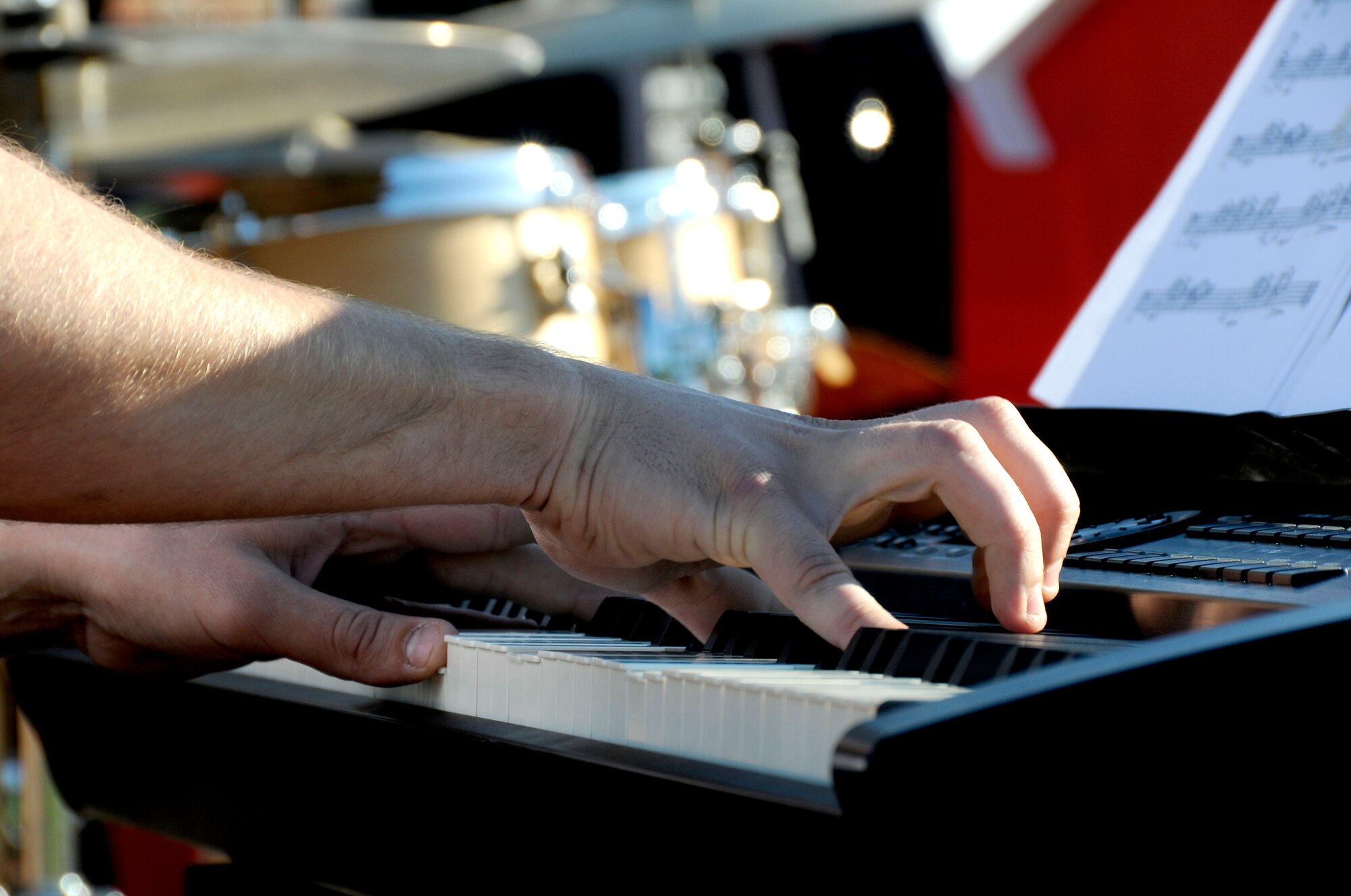 Airman 1st Class Adam Braatz fingers hit the keys during the United States Air Force Band of Mid-America's concert at Scott AFB parade field, June 6, 2010. The Shades of Blue Jazz Ensemble performed in front of Team Scott to kick off the summer concert series. Upcoming performances in the summer concert series include Starlifter, Aug. 1, and the concert band Aug. 29. (U.S. Air Force photo by Staff Sgt. Brian J. Ellis)