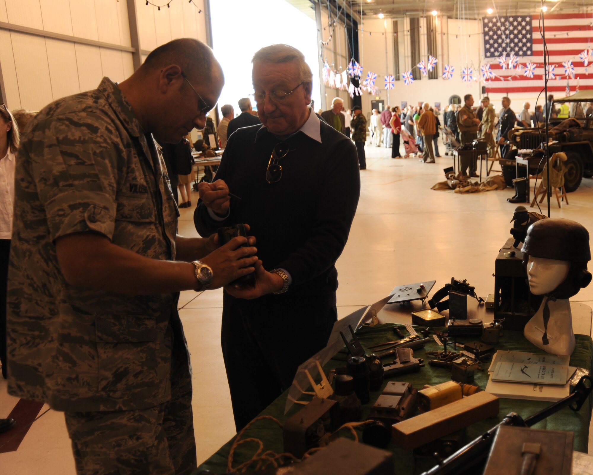 RAF FAIRFORD, United Kingdom - (Left) Major William Villegas, 420th Munitions Squadron commander, is shown historic mock explosives at Heritage Day June 9. The event focused on RAF Fairford's history in the local community, and how important the local communities have been to the base over the years. (U.S. Air Force photo by Staff Sgt. Joel Mease)