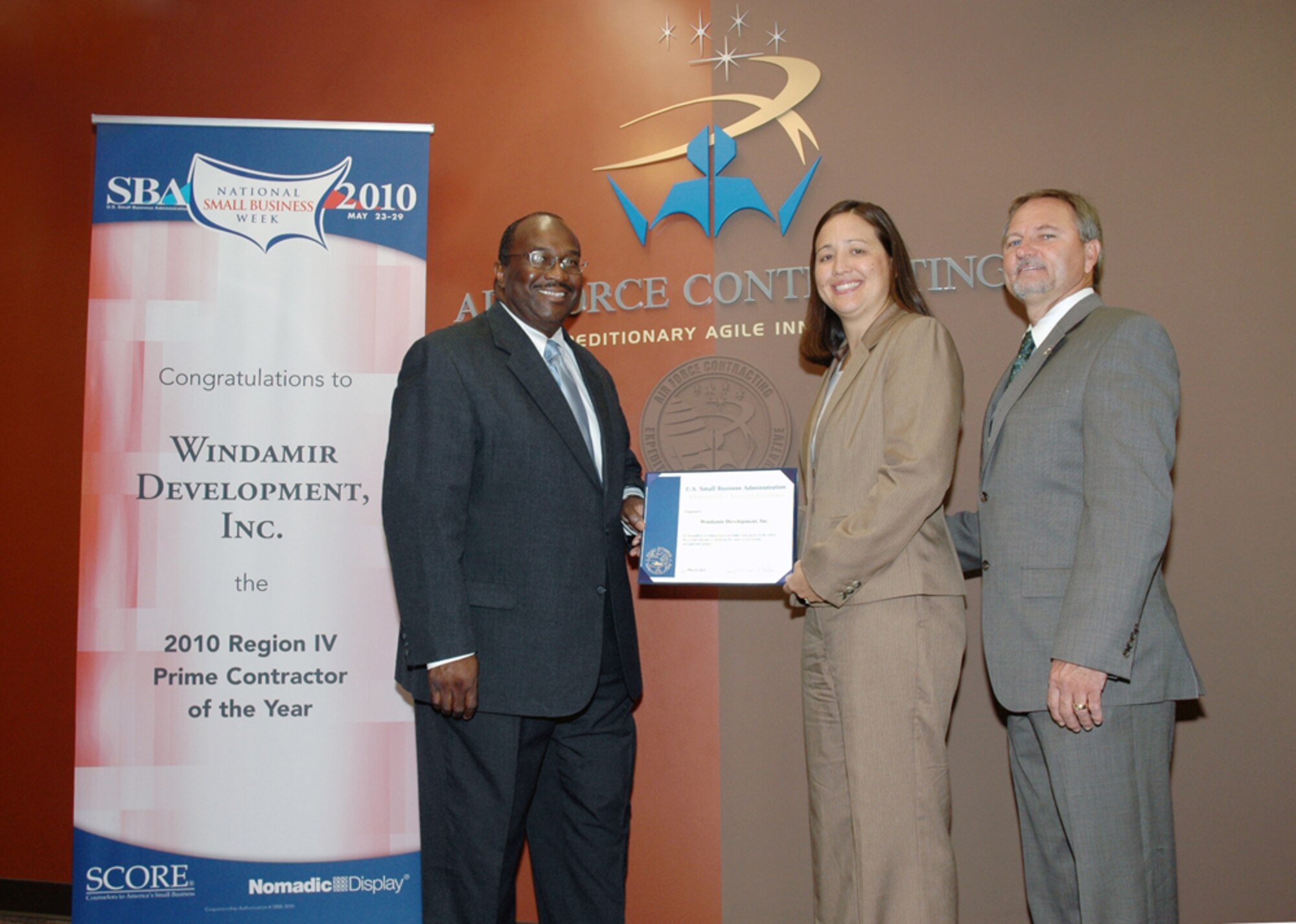 Mitchell Morend, U.S. Small Business Administration area director, presents award certificate to Kimberly Glover, president of Windamir Development, Inc., and Doug Glover, during a recognition ceremony at Dobbins contracting office June 10.

