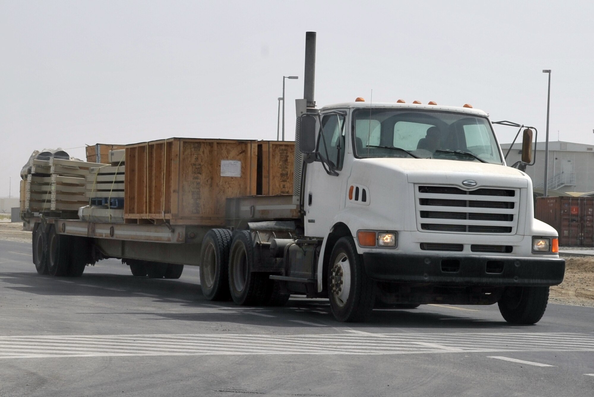 An Airman from the 380th Expeditionary Civil Engineer Squadron drives a tractor-trailer with new infrastructure equipment during operations for the 380th Air Expeditionary Wing June 11, 2010, at a non-disclosed base in Southwest Asia. Civil engineering Airmen having been working continuously for more than two months on multi-million dollar upgrades to airfield structures and other infrastructure projects for the 380th AEW.  The new structures, officials say, will allow for increased efficiency in airfield and base operations. The 380th AEW supports operations Iraqi Freedom and Enduring Freedom and the Combined Joint Task Force-Horn of Africa. (U.S. Air Force Photo/Master Sgt. Scott T. Sturkol/Released)