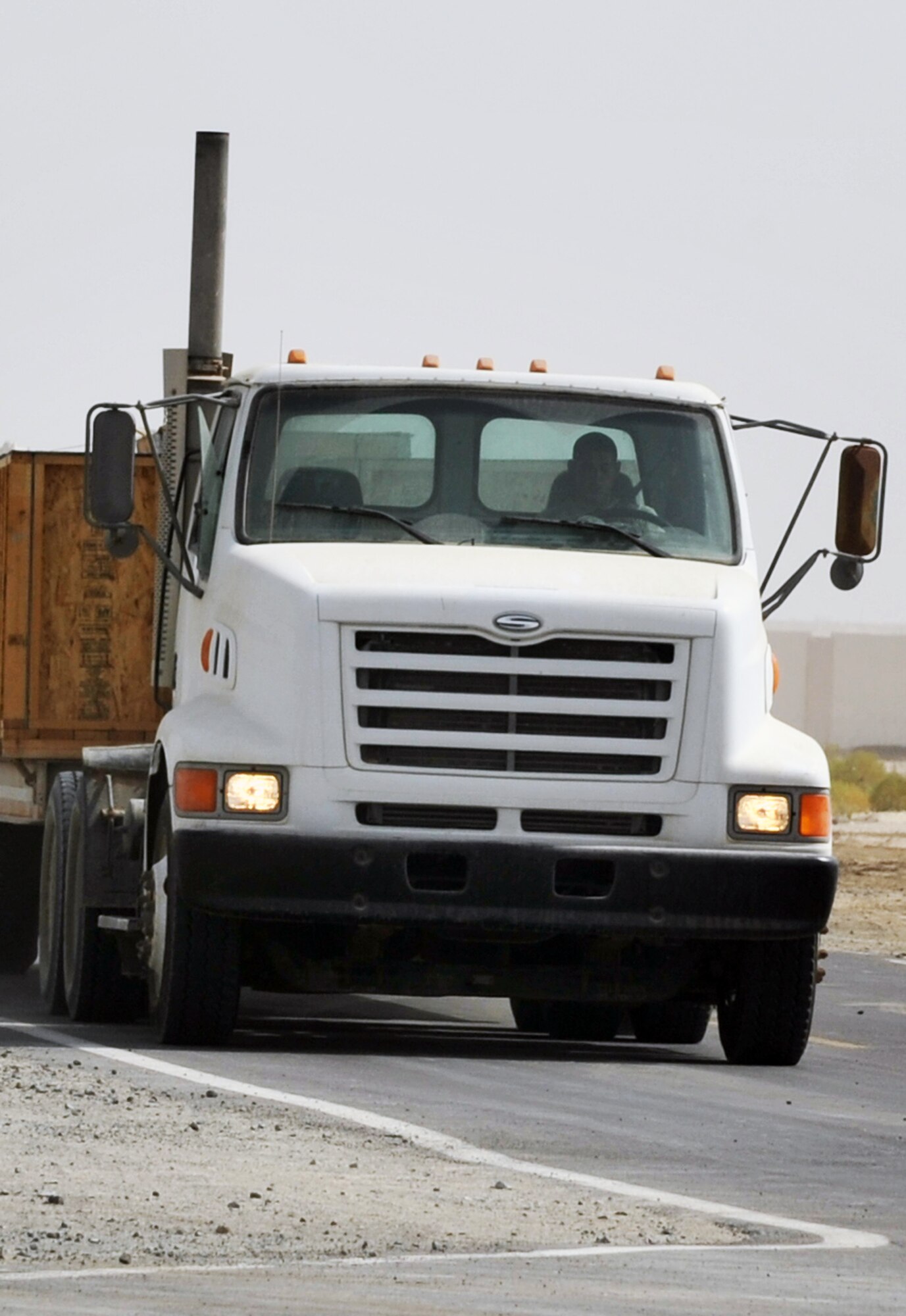 An Airman from the 380th Expeditionary Civil Engineer Squadron drives a tractor-trailer with new infrastructure equipment during operations for the 380th Air Expeditionary Wing June 11, 2010, at a non-disclosed base in Southwest Asia. Civil engineering Airmen having been working continuously for more than two months on multi-million dollar upgrades to airfield structures and other infrastructure projects for the 380th AEW.  The new structures, officials say, will allow for increased efficiency in airfield and base operations. The 380th AEW supports operations Iraqi Freedom and Enduring Freedom and the Combined Joint Task Force-Horn of Africa. (U.S. Air Force Photo/Master Sgt. Scott T. Sturkol/Released)
