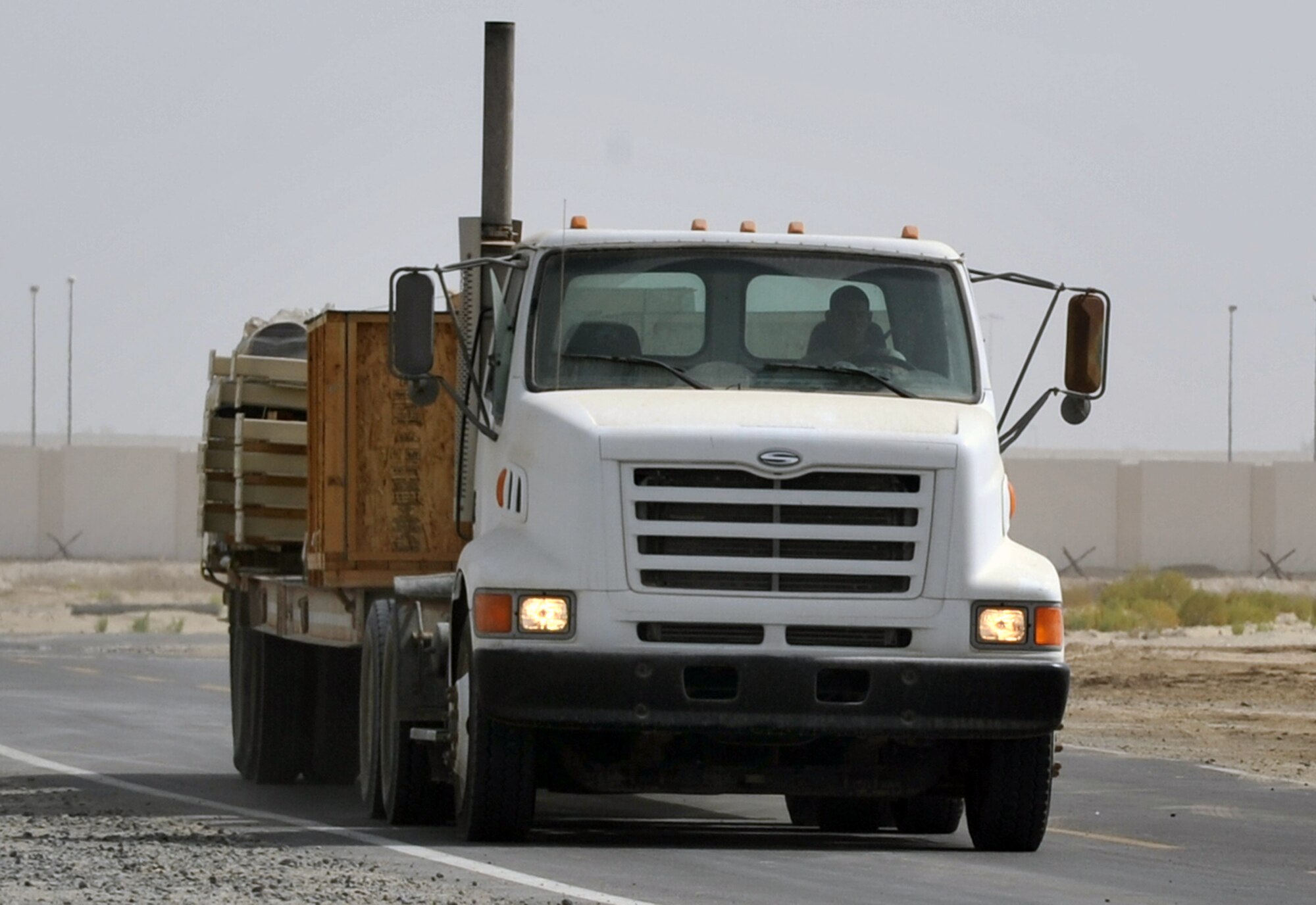 An Airman from the 380th Expeditionary Civil Engineer Squadron drives a tractor-trailer with new infrastructure equipment during operations for the 380th Air Expeditionary Wing June 11, 2010, at a non-disclosed base in Southwest Asia. Civil engineering Airmen having been working continuously for more than two months on multi-million dollar upgrades to airfield structures and other infrastructure projects for the 380th AEW.  The new structures, officials say, will allow for increased efficiency in airfield and base operations. The 380th AEW supports operations Iraqi Freedom and Enduring Freedom and the Combined Joint Task Force-Horn of Africa. (U.S. Air Force Photo/Master Sgt. Scott T. Sturkol/Released)