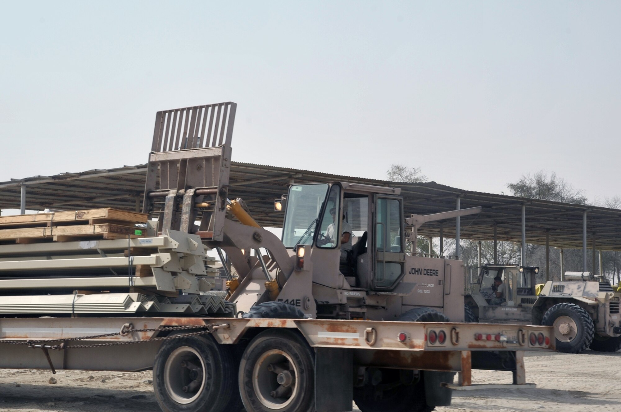 Airmen from the 380th Expeditionary Civil Engineer Squadron load a tractor-trailer with new infrastructure equipment during operations for the 380th Air Expeditionary Wing June 11, 2010, at a non-disclosed base in Southwest Asia. Civil engineering Airmen having been working continuously for more than two months on multi-million dollar upgrades to airfield structures and other infrastructure projects for the 380th AEW.  The new structures, officials say, will allow for increased efficiency in airfield and base operations. The 380th AEW supports operations Iraqi Freedom and Enduring Freedom and the Combined Joint Task Force-Horn of Africa. (U.S. Air Force Photo/Master Sgt. Scott T. Sturkol/Released)
