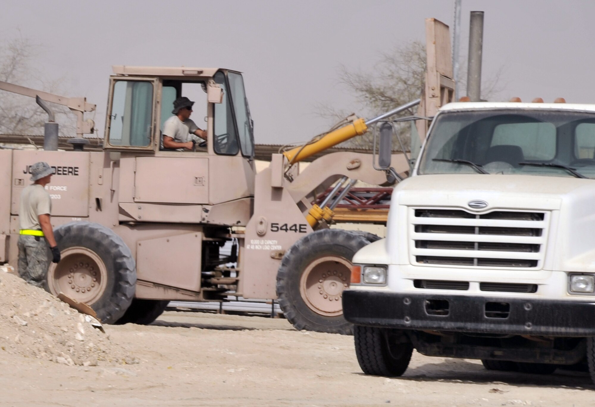 Airmen from the 380th Expeditionary Civil Engineer Squadron load a tractor-trailer with new infrastructure equipment during operations for the 380th Air Expeditionary Wing June 11, 2010, at a non-disclosed base in Southwest Asia. Civil engineering Airmen having been working continuously for more than two months on multi-million dollar upgrades to airfield structures and other infrastructure projects for the 380th AEW.  The new structures, officials say, will allow for increased efficiency in airfield and base operations. The 380th AEW supports operations Iraqi Freedom and Enduring Freedom and the Combined Joint Task Force-Horn of Africa. (U.S. Air Force Photo/Master Sgt. Scott T. Sturkol/Released)
