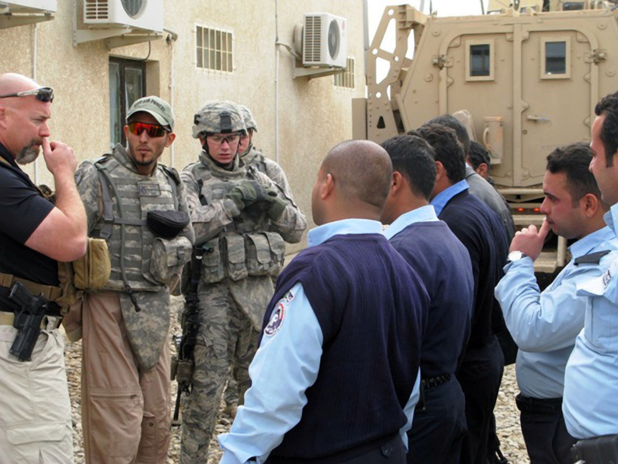 An Iraqi Police Advisor, a translator and defenders with the 732nd Expeditionary Security Forces Squadron, Detachment 3, talk to Iraqi Police during training at the Taji Law Enforcement Academy at Camp Taji, Iraq. The defenders and advisors were at the academy serving in an advise and assist role where Iraqi Officers trained other Iraqi Police. The academy closed June 3, 2010, as a local training academy, but training will continue at the directorate level at a regional training center in Baghdad. (Photo courtesy of the 732nd ESFS, Det. 3/Released)