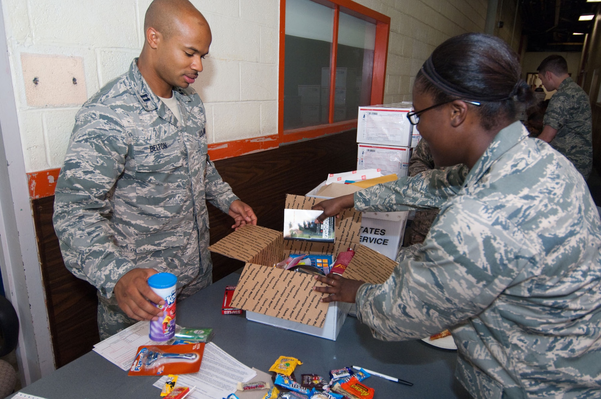 HANSCOM AIR FORCE BASE, Mass. – Capt. Scott Belton (left) and Capt. Tchoia Brown place items into a care package during the Company Grade Officers Council’s Troop Care Drive on June 3. Twenty-five volunteers assembled approximately 200 care packages for deployed troops and prepared them for shipping from 8 a.m. to 4 p.m. in Building 1105A. (U.S. Air Force photo by Rick Berry)