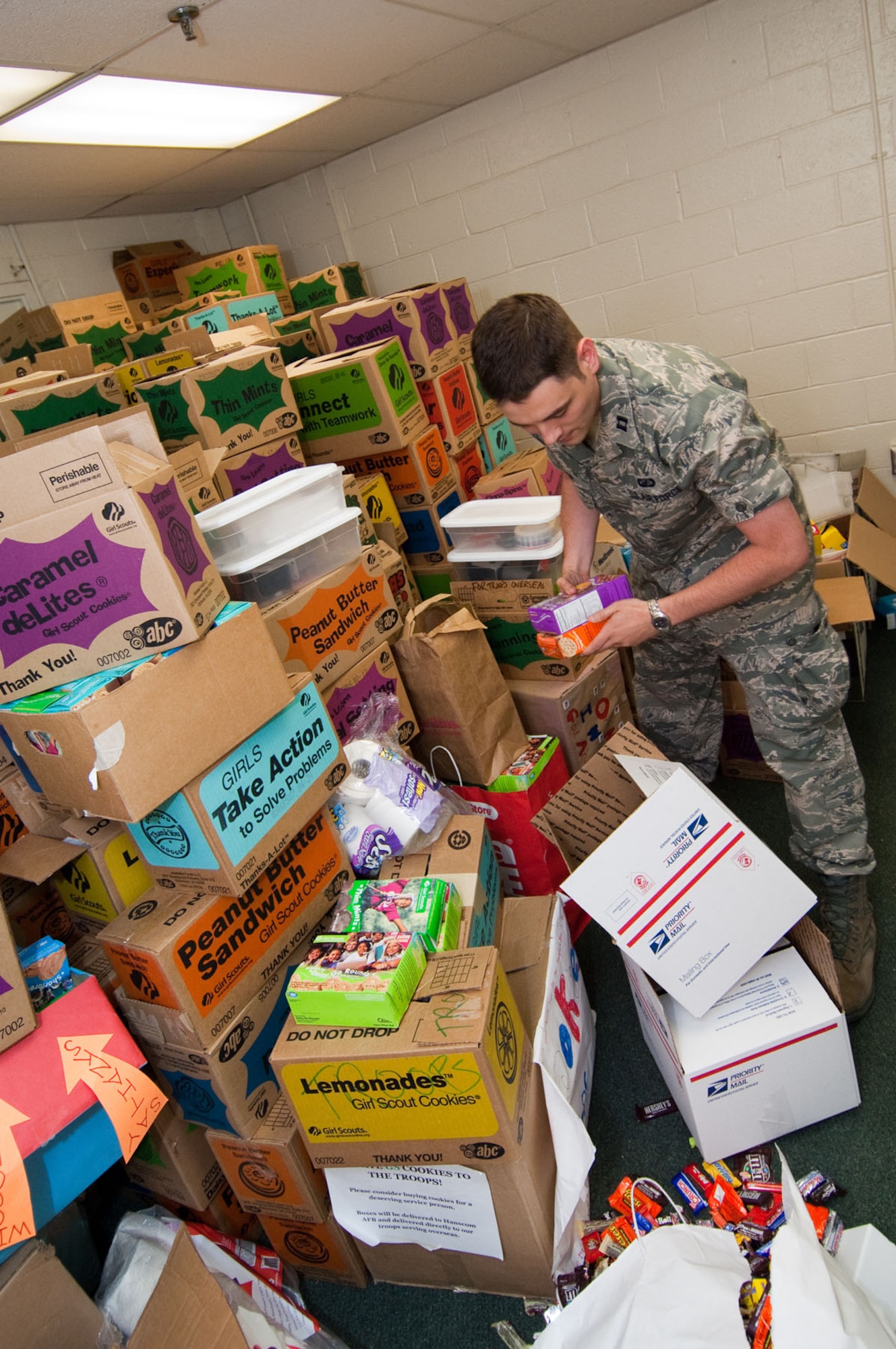 HANSCOM AIR FORCE BASE, Mass. – Capt. Matthew Carter picks out items to include in a care package during the Company Grade Officers Council’s  Troop Care Drive on June 3. Twenty-five volunteers assembled approximately 200 care packages for deployed troops and prepared them for shipping from 8 a.m. to 4 p.m. in Building 1105A. (U.S. Air Force photo by Rick Berry)