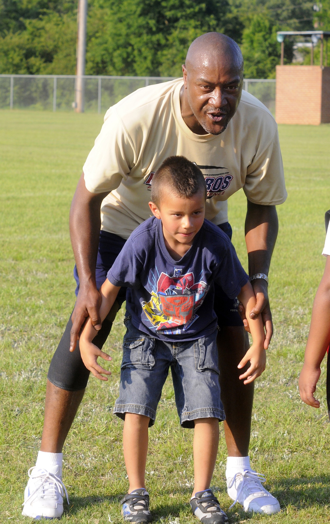 Darryl Holmes, former New England Patriot, coaches Matthew Cox on his stance during a drill at Kids & Pros Youth Football Camp. U. S. Air Force photo by Sue Sapp