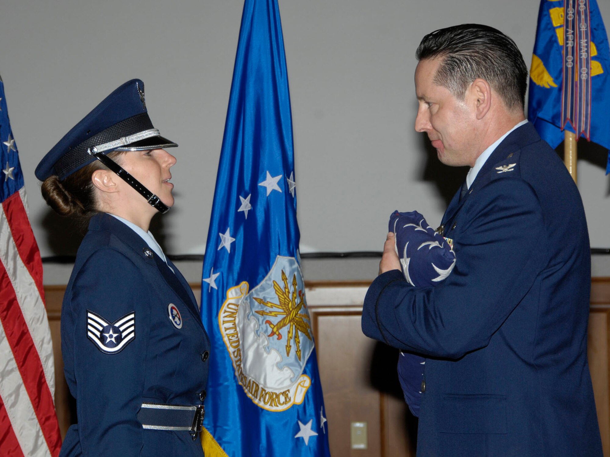 HANSCOM AIR FORCE BASE, Mass. - Col. David DeNofrio accepts a flag from Staff Sgt. Lori Jones, Patriot Honor Guard cadre, during his retirement ceremony May 27.  The colonel, who will be retiring from the Air Force July 1 with more than 25 years of service, was commander of the 950th Electronic Systems Group until June 1.  The flag was flown at places significant to the colonel, including the U.S. Capitol, Norwich University and in a B-1 test sortie.  (Photo by Linda LaBonte Britt)
