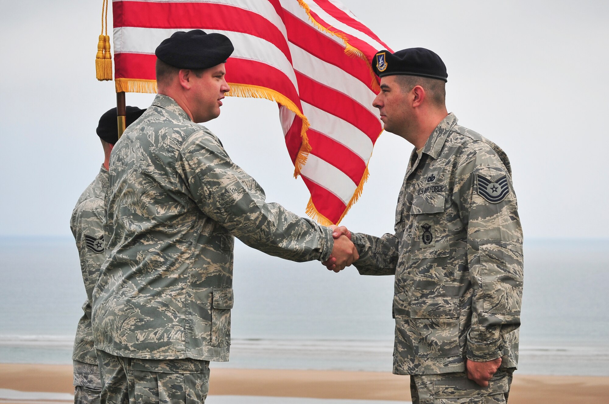 NORMANDY, France – Capt. Andrew Legault, left, 701st Munitions Support Squadron custody forces chief, shakes the hand of Tech. Sgt. Joshua Clark, 701st MUNSS custody forces, after his reenlistment June 6. Sergeant Clark has served in the Air Force for more than 11 years and is originally from Arlington, Texas. (courtesy photo/Ruth Dias)