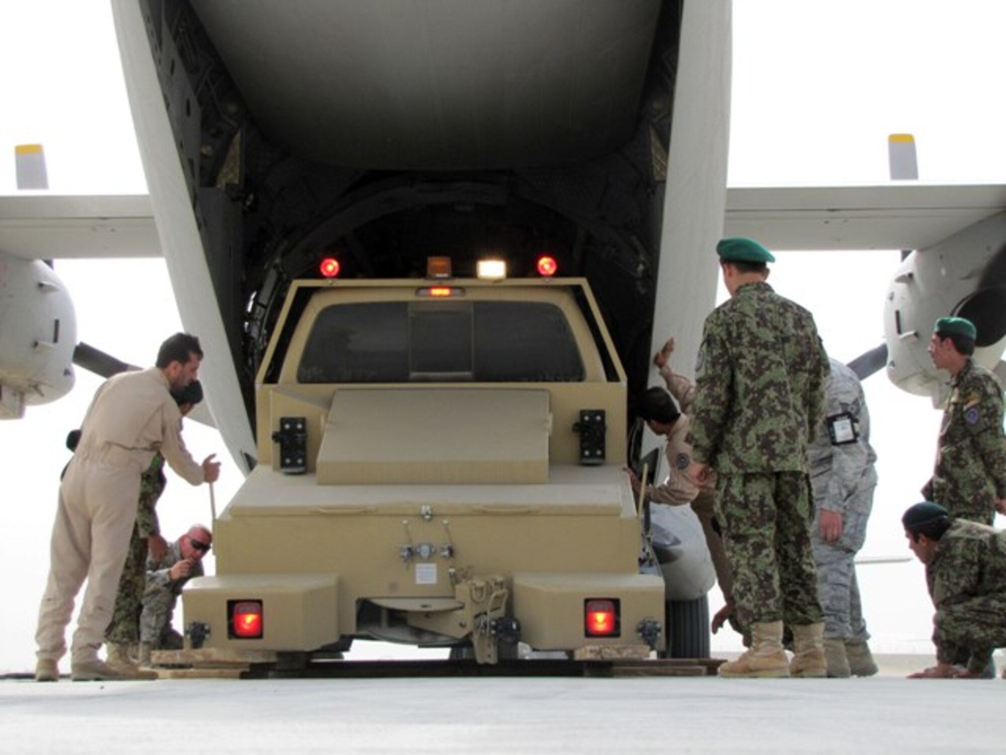 Members of the Afghan National Army Air Corps load a tug truck bound for Herat on a C-27 Spartan June 8, 2010, at Kabul International Airport, Afghanistan. This was the first operational heavy-equipment airlift mission planned and conducted by ANAAC soldiers. (U.S. Air Force photo by Capt. Rob Leese/RELEASED).
